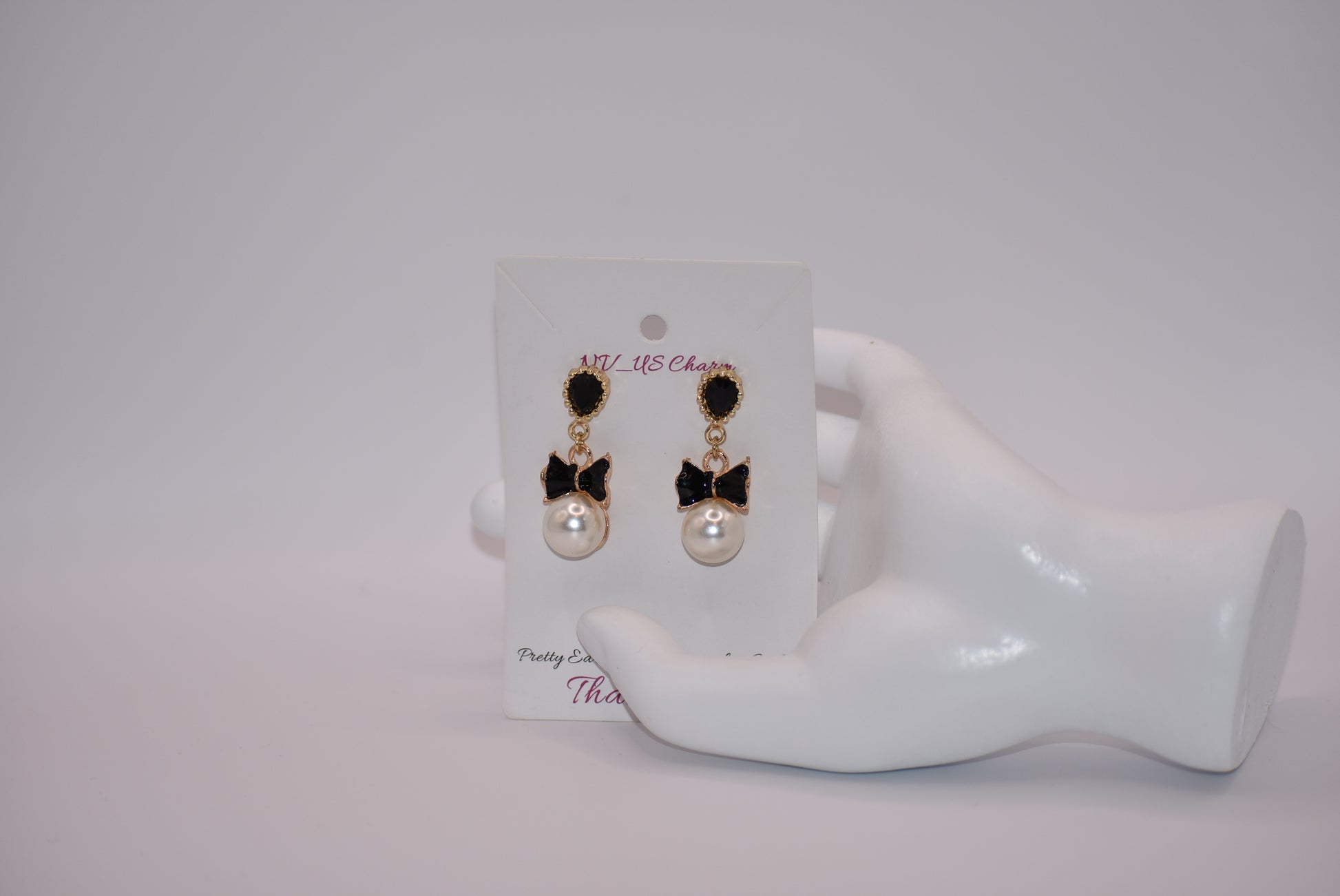 Introducing our Wedding Collection, the perfect choice for those looking for unique and stylish earrings. Our black and gold pear shaped posts feature a stunning large pearl and black tie charm, adding a touch of elegance to any outfit. Crafted with comfort and hypoallergenic materials, these earrings are perfect for sensitive ears.