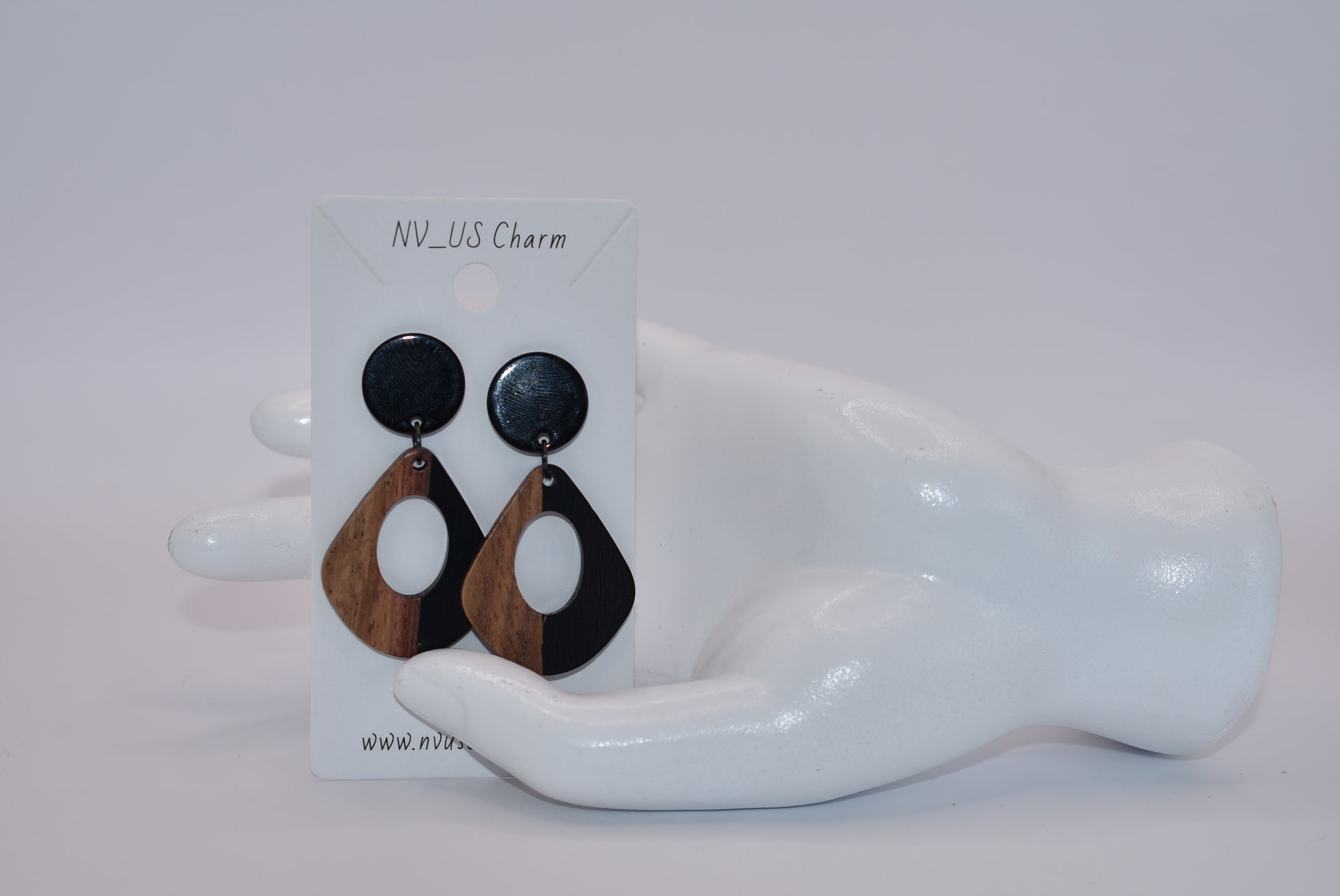 Elevate your wardrobe with our Black Collection! These stunning oval earrings, held by black round posts, will perfectly complement any outfit. Whether dressing up or down, these black resin and wood beauties are sure to make a statement. A must-have for any fashionista!