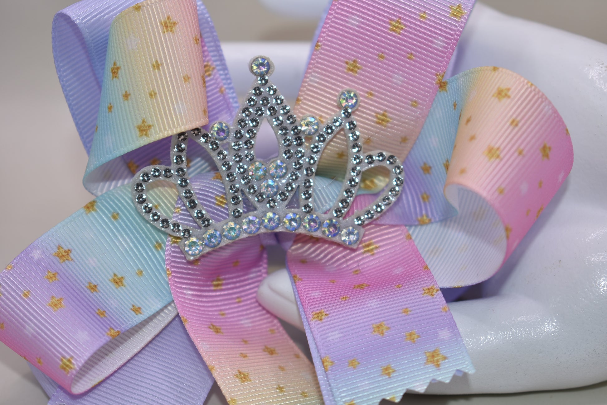 Nana's Collection presents the Perfect Princess Bow! 👑✨ This soft rainbow-colored beauty is adorned with pretty gold stars ⭐ and topped with a big sparkly crown 👸 for that royal touch! The wrapped alligator clip ensures all-day wear without slipping. 🌈 Transform any outfit into a majestic ensemble fit for your little princess! 💖