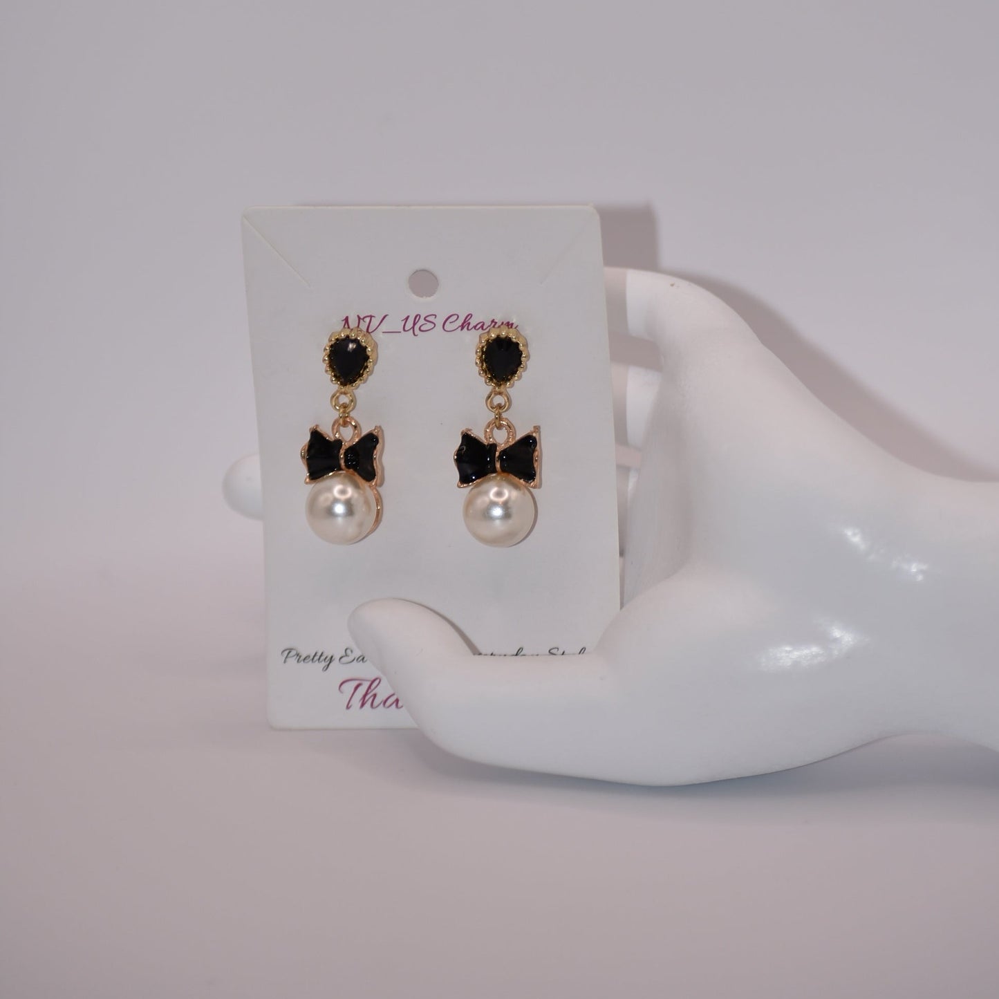 Introducing our Wedding Collection, the perfect choice for those looking for unique and stylish earrings. Our black and gold pear shaped posts feature a stunning large pearl and black tie charm, adding a touch of elegance to any outfit. Crafted with comfort and hypoallergenic materials, these earrings are perfect for sensitive ears.