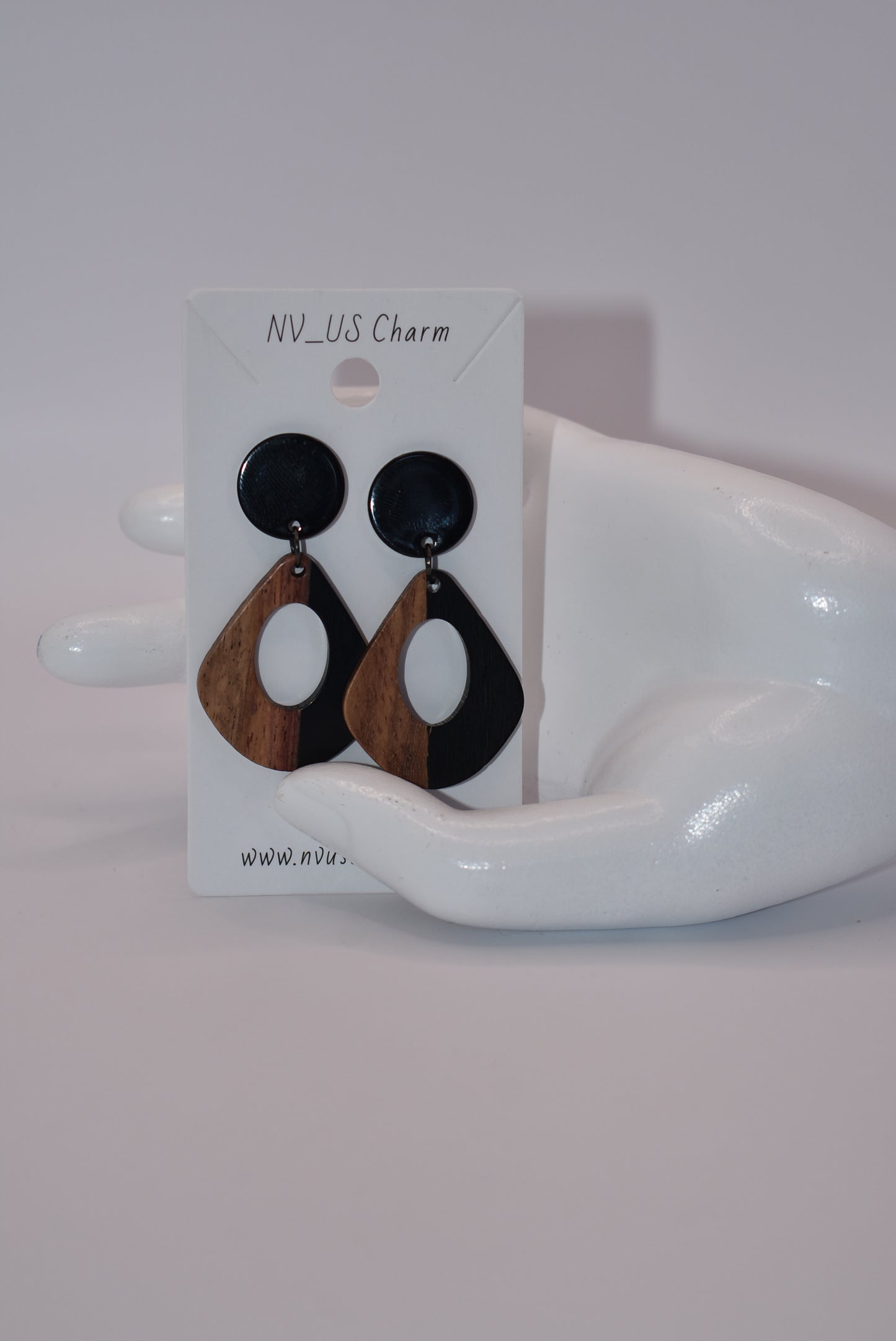 Elevate your wardrobe with our Black Collection! These stunning oval earrings, held by black round posts, will perfectly complement any outfit. Whether dressing up or down, these black resin and wood beauties are sure to make a statement. A must-have for any fashionista!