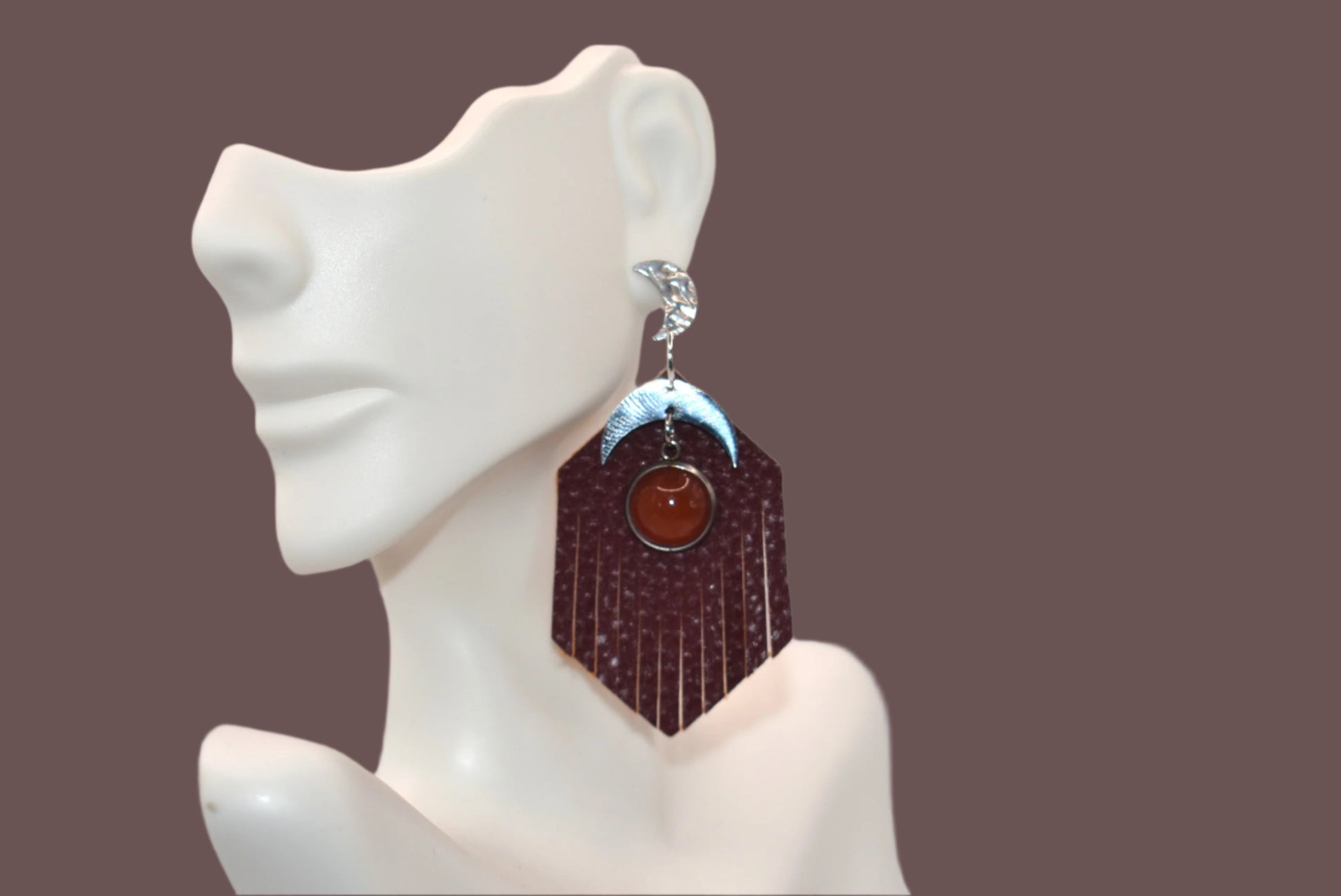 Introducing our Brown Collection! These stainless-steel hypoallergenic posts are perfect for sensitive ears. The brown fringed faux leather background adds a touch of elegance, while the stainless-steel half-moon charm and brown cabochon stone add a unique twist. Gotta have it!