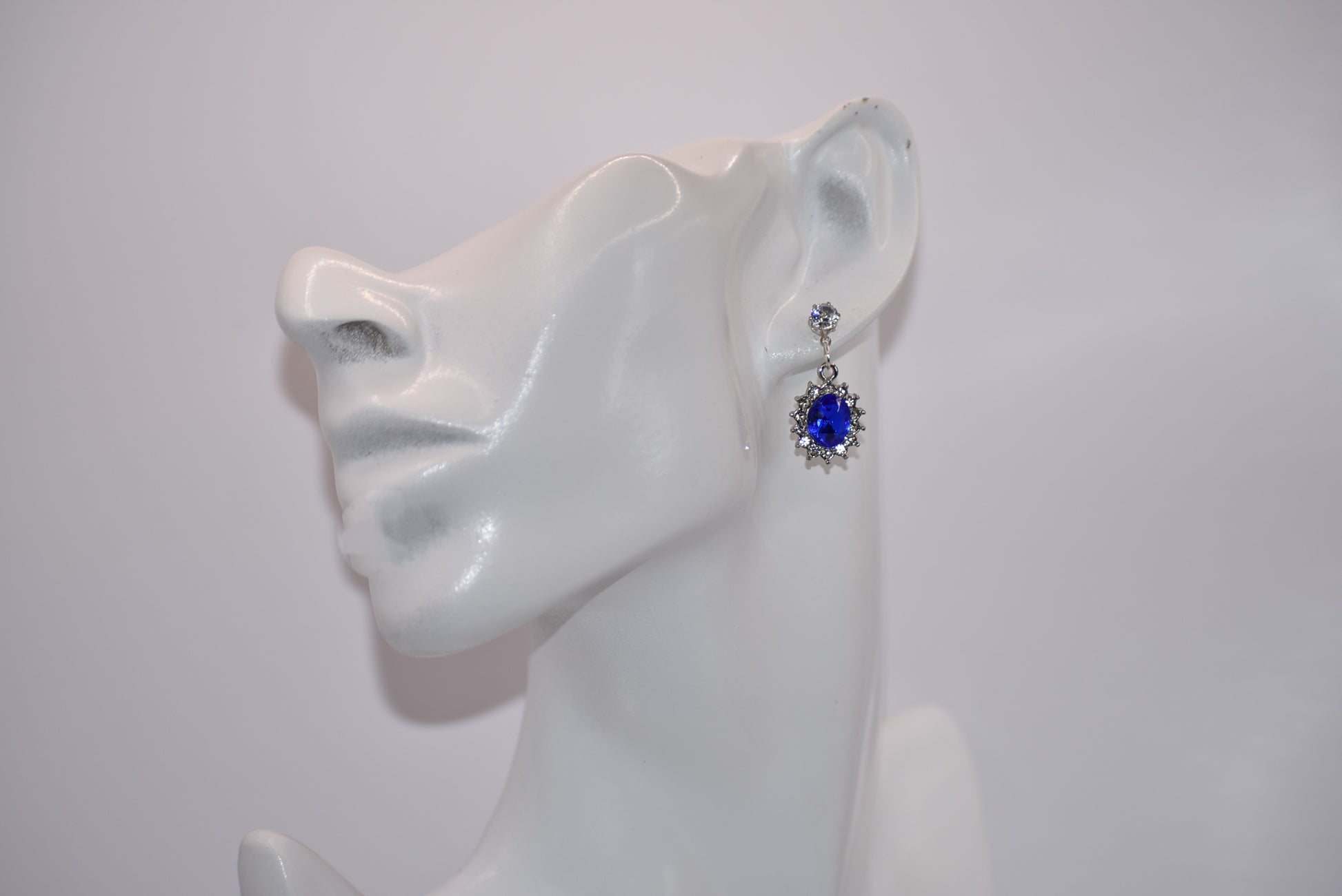 "Add a touch of sparkle to any outfit with our Blue Collection earrings. These hypoallergenic studs feature a pretty cubic zirconia crystal and a stunning cobalt blue gem. Perfect for dressing up or down, they are both comfortable and eye-catching. A must-have addition to any jewelry collection! (Seriously, you won't regret it.)"