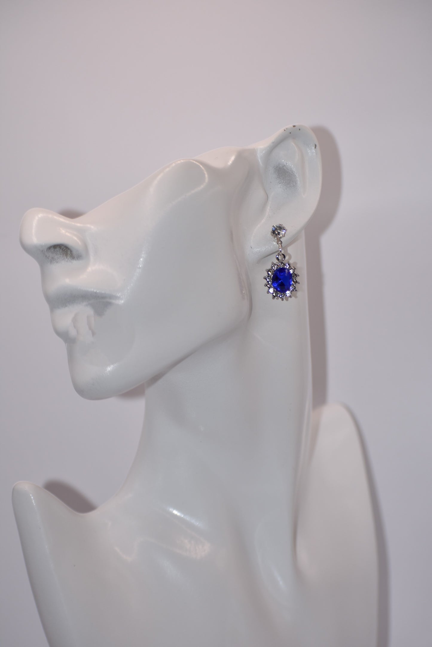 "Add a touch of sparkle to any outfit with our Blue Collection earrings. These hypoallergenic studs feature a pretty cubic zirconia crystal and a stunning cobalt blue gem. Perfect for dressing up or down, they are both comfortable and eye-catching. A must-have addition to any jewelry collection! (Seriously, you won't regret it.)"