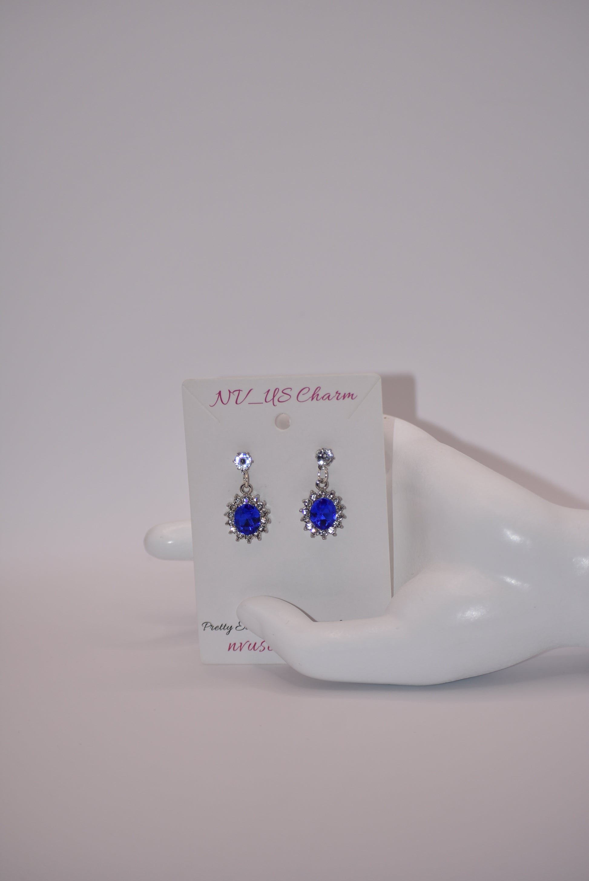 "Add a touch of sparkle to any outfit with our Blue Collection earrings. These hypoallergenic studs feature a pretty cubic zirconia crystal and a stunning cobalt blue gem. Perfect for dressing up or down, they are both comfortable and eye-catching. A must-have addition to any jewelry collection! (Seriously, you won't regret it.)"