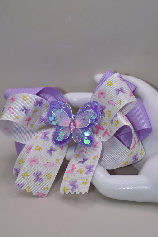Delightful purple and pink butterflies 🦋 dance across this gorgeous bow! 🎀 Multiple layers of premium ribbon create a stunning design that's sure to turn heads! ✨ The wrapped alligator clip ensures this beauty stays securely in place all day long. 👧 Perfect for adding a touch of whimsy to any outfit! 💜💕
