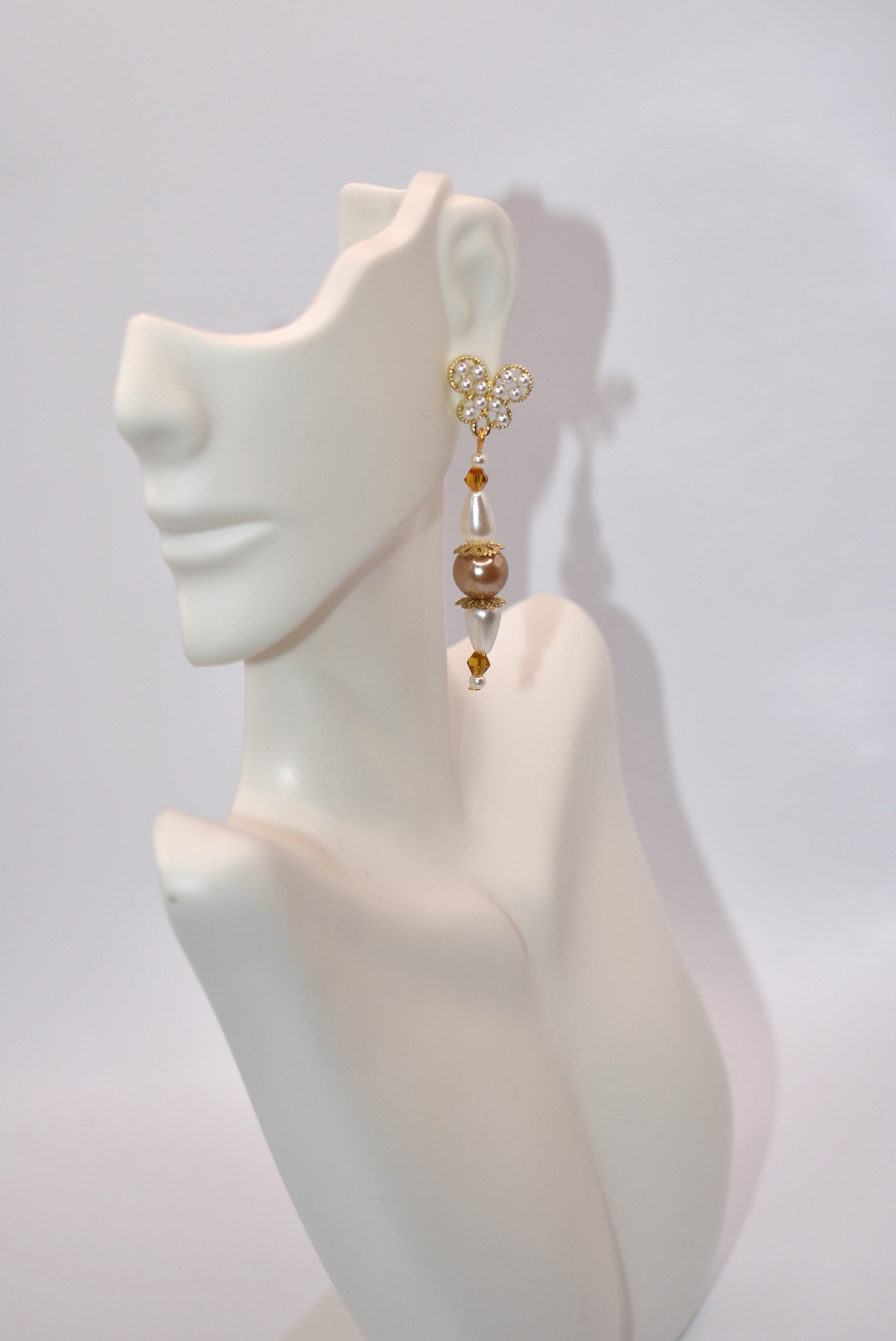 Add some whimsy to your wardrobe with our Brown Collection! These hypoallergenic earrings feature tiny pearl butterfly posts and a mix of pretty pearls and crystals hanging approximately 1 1/2 inches from your ear. Comfortable and stylish, these earrings are perfect for any occasion.