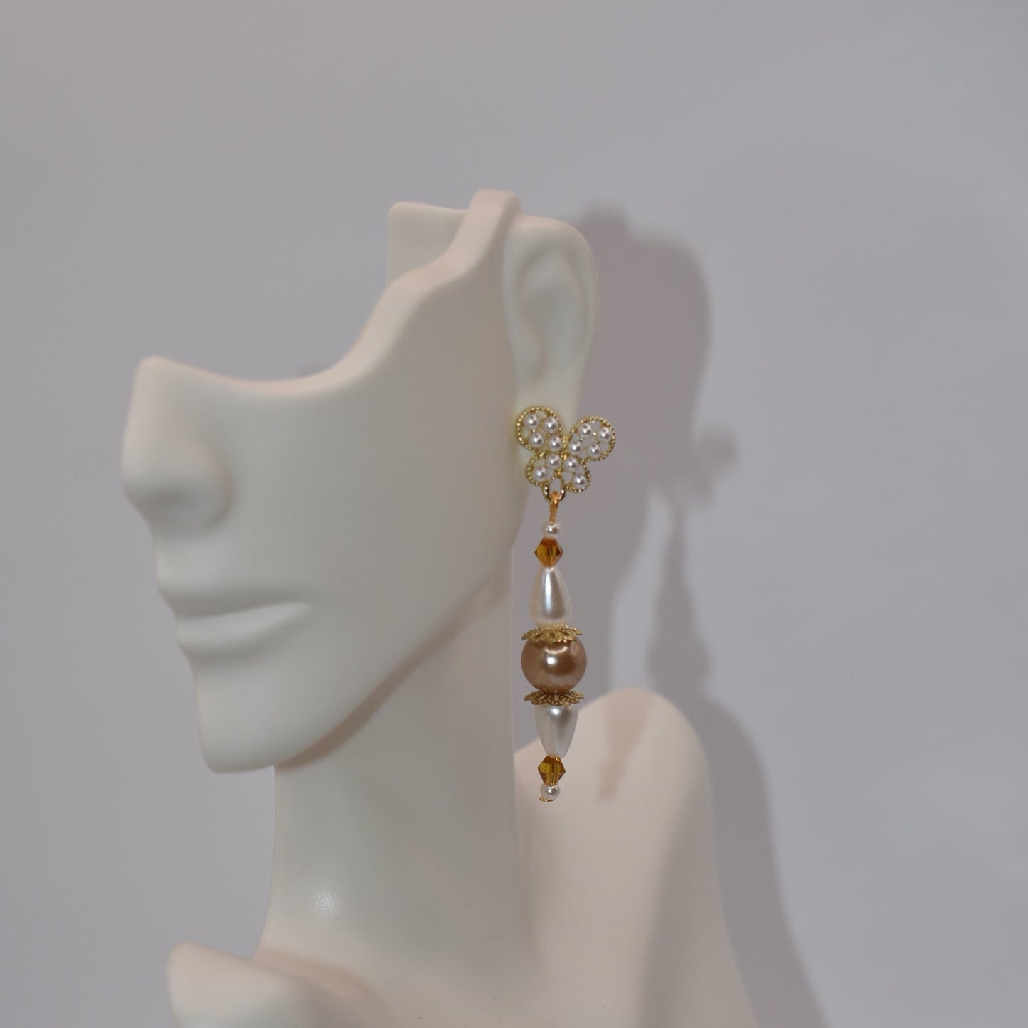 Add some whimsy to your wardrobe with our Brown Collection! These hypoallergenic earrings feature tiny pearl butterfly posts and a mix of pretty pearls and crystals hanging approximately 1 1/2 inches from your ear. Comfortable and stylish, these earrings are perfect for any occasion.