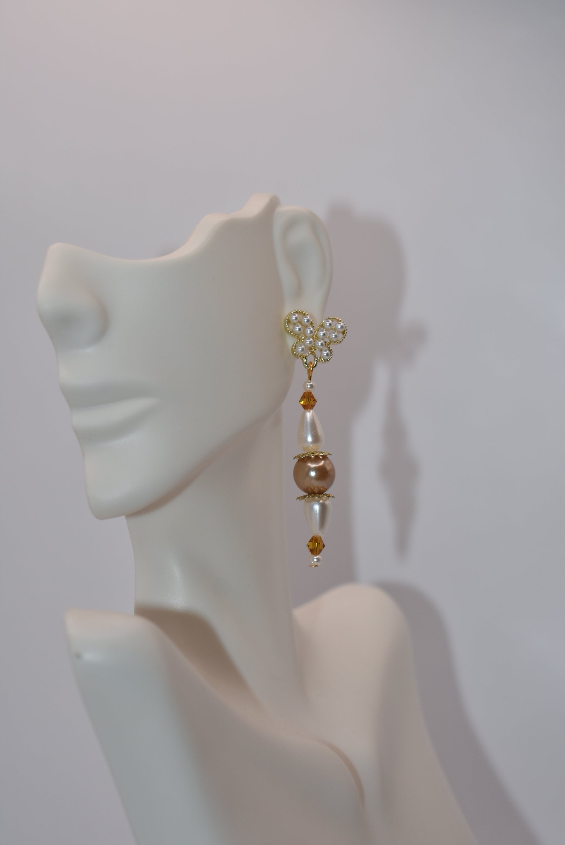 Add some whimsy to your wardrobe with our Brown Collection! These hypoallergenic earrings feature tiny pearl butterfly posts and a mix of pretty pearls and crystals hanging approximately 1 1/2 inches from your ear. Comfortable and stylish, these earrings are perfect for any occasion.