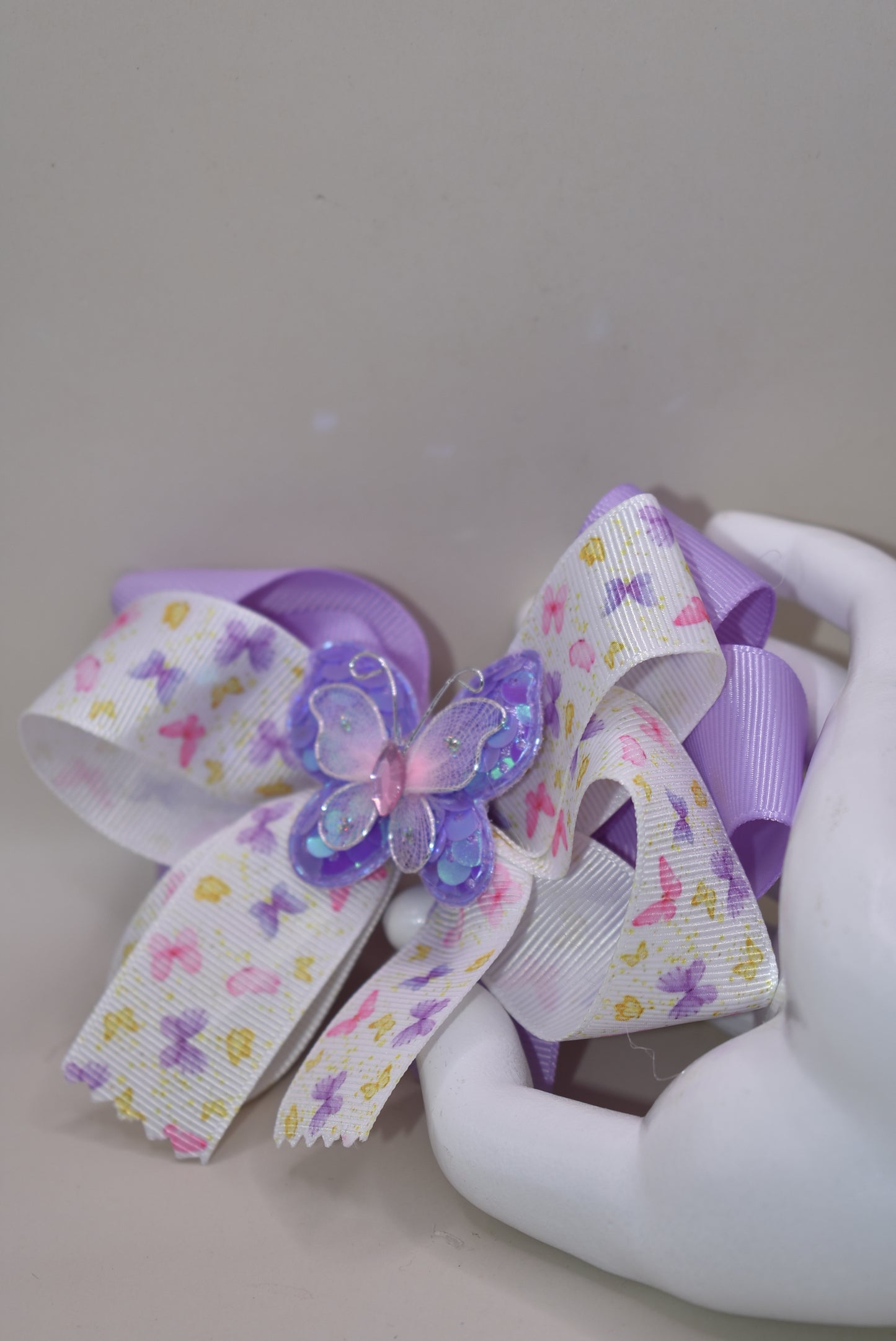Delightful purple and pink butterflies 🦋 dance across this gorgeous bow! 🎀 Multiple layers of premium ribbon create a stunning design that's sure to turn heads! ✨ The wrapped alligator clip ensures this beauty stays securely in place all day long. 👧 Perfect for adding a touch of whimsy to any outfit! 💜💕