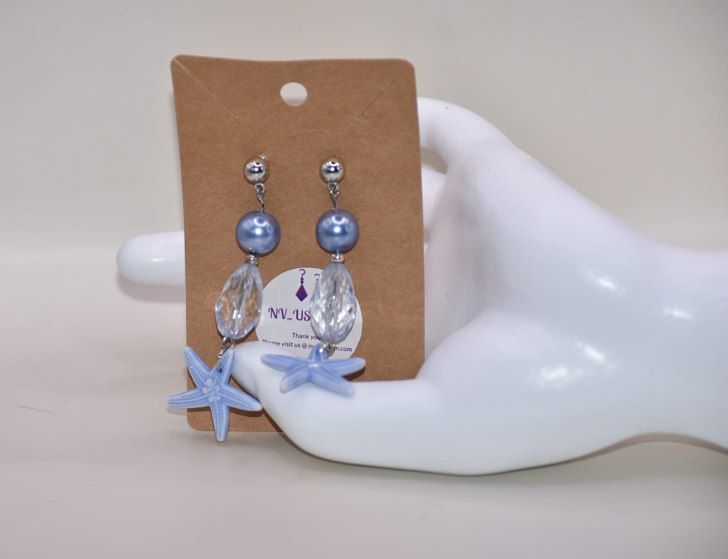 ⚓️ Add a touch of nautical elegance to your wardrobe with our Nautical Collection! These stunning blue pearl, crystal and starfish earrings are held securely by silver hypoallergenic posts. Lightweight and comfortable, they hang 2" off the ear. Perfect for any occasion!