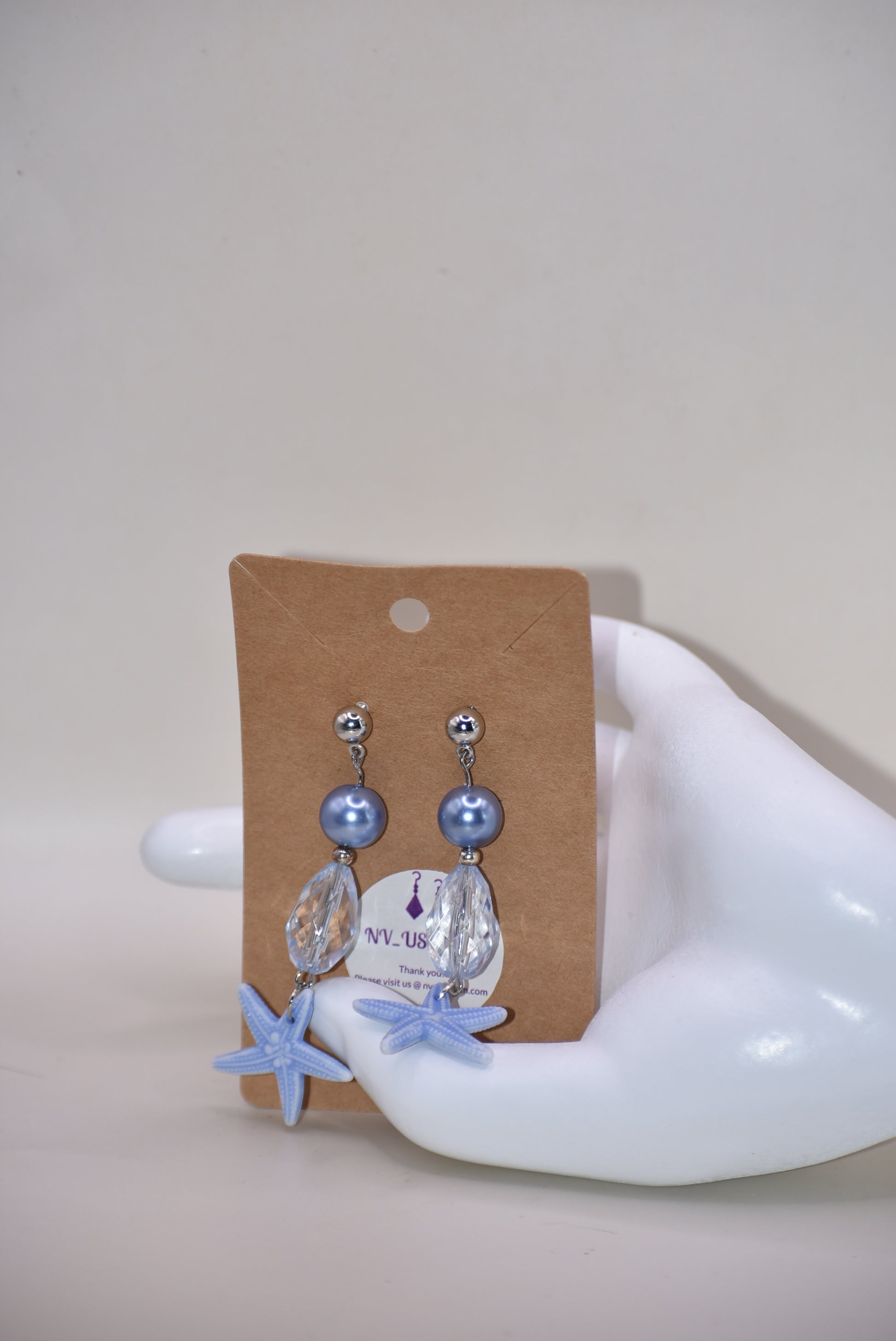 ⚓️ Add a touch of nautical elegance to your wardrobe with our Nautical Collection! These stunning blue pearl, crystal and starfish earrings are held securely by silver hypoallergenic posts. Lightweight and comfortable, they hang 2" off the ear. Perfect for any occasion!