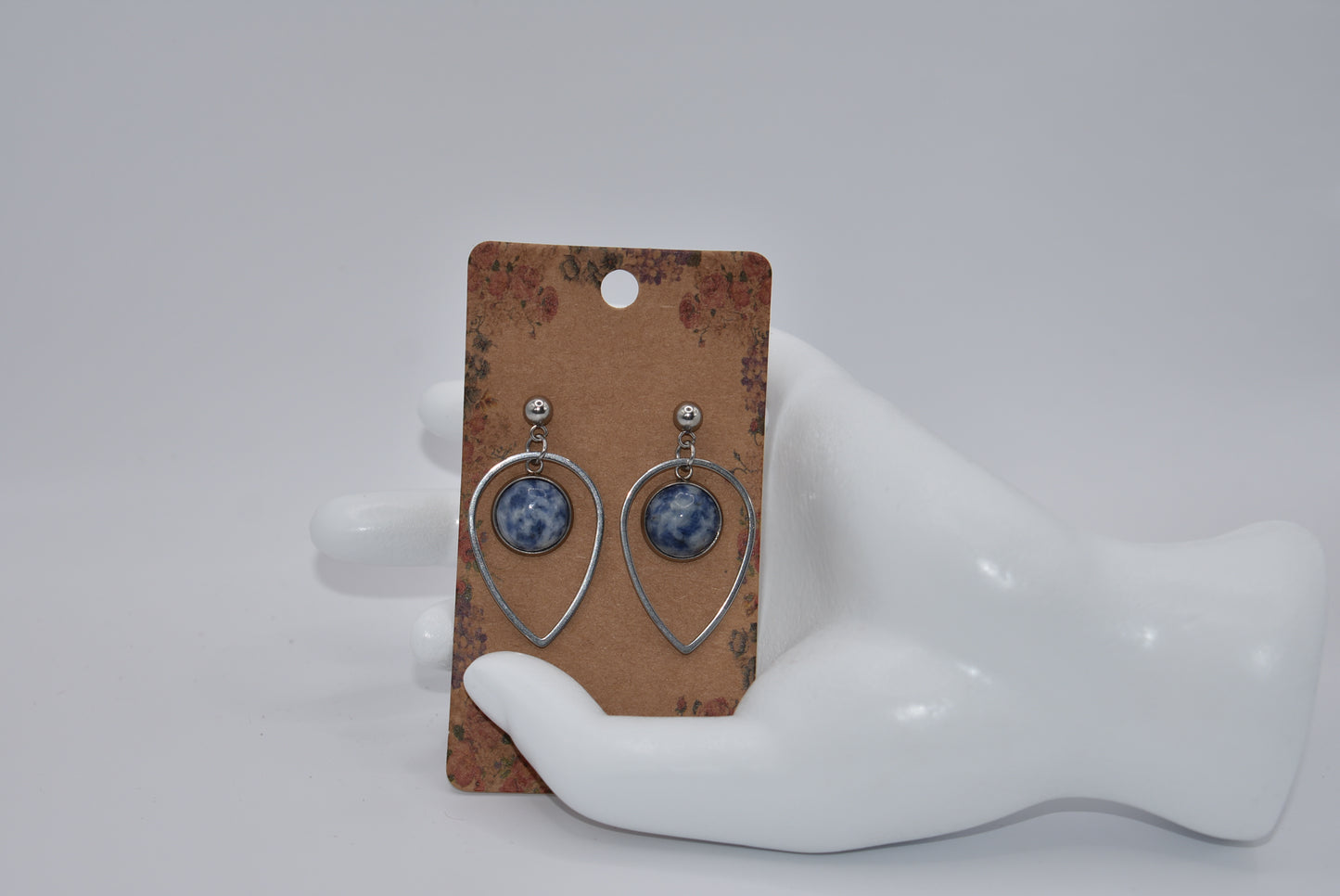 "Add some unique flair to your everyday look with our Blue Collection earrings! These silver hypoallergenic posts hold a teardrop open with a stunning cabochon stone center, ensuring both style and comfort. Perfect for all-day wear. (Your ears will thank you.)"