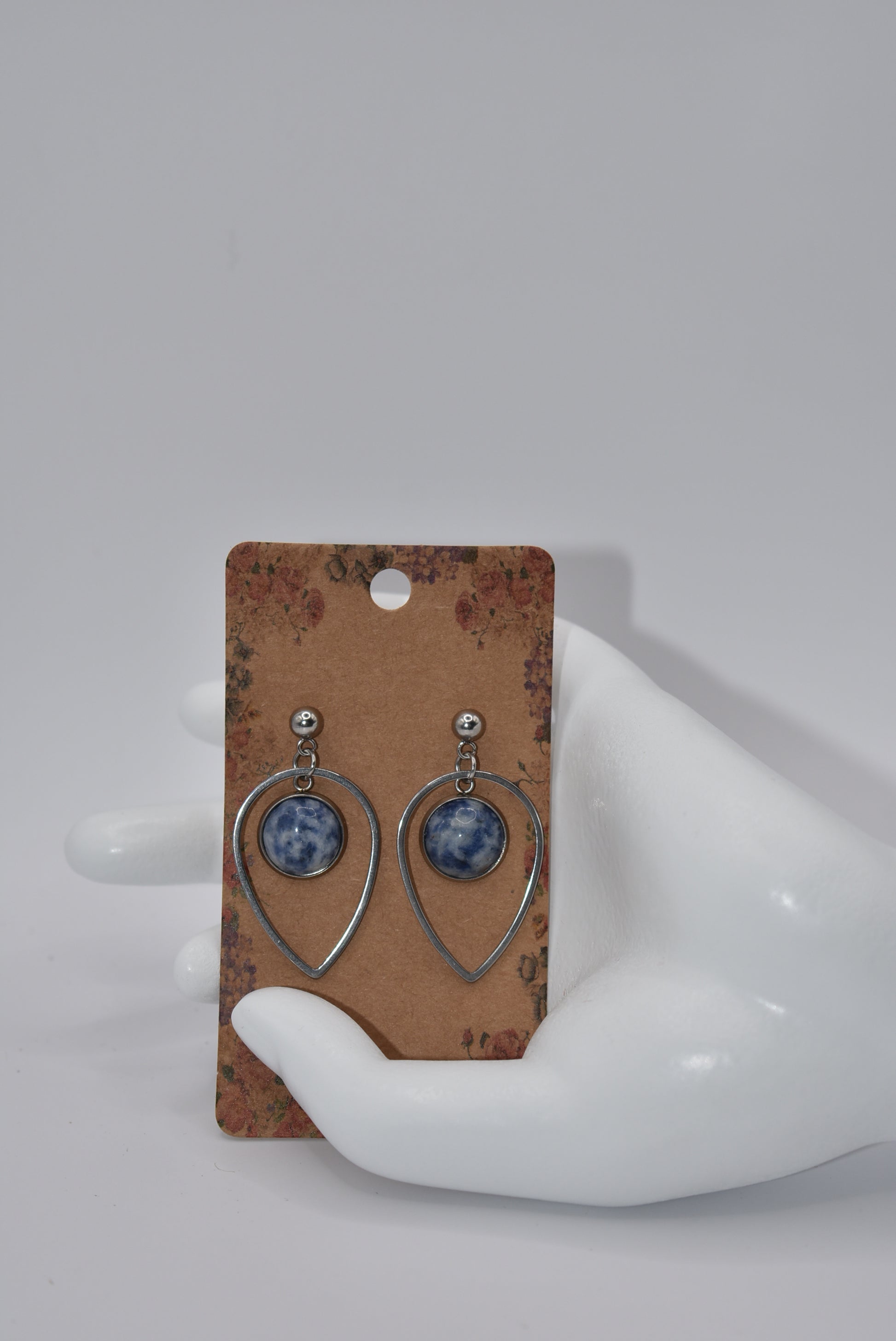 "Add some unique flair to your everyday look with our Blue Collection earrings! These silver hypoallergenic posts hold a teardrop open with a stunning cabochon stone center, ensuring both style and comfort. Perfect for all-day wear. (Your ears will thank you.)"