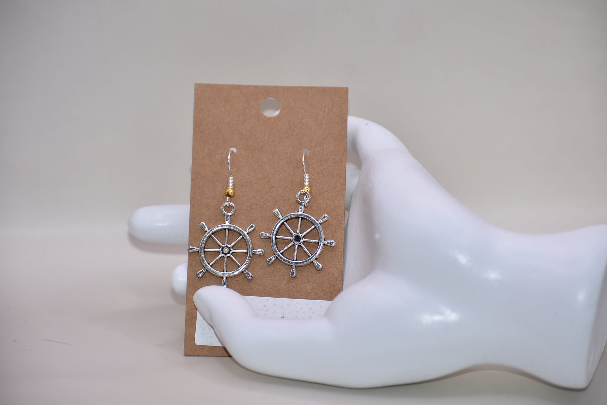 "Add some nautical charm to your look with these adorable wheel earrings ⚓ Made with hypoallergenic silver hooks and a stylish gold ball, these earrings are perfect for any outfit. Look cute and feel comfortable with the Nautical Collection!"