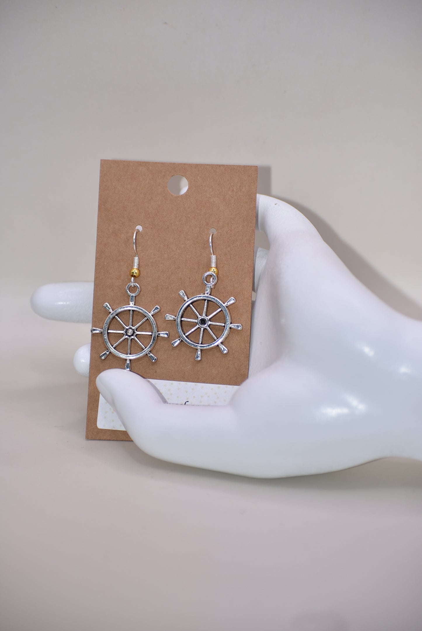 "Add some nautical charm to your look with these adorable wheel earrings ⚓ Made with hypoallergenic silver hooks and a stylish gold ball, these earrings are perfect for any outfit. Look cute and feel comfortable with the Nautical Collection!"