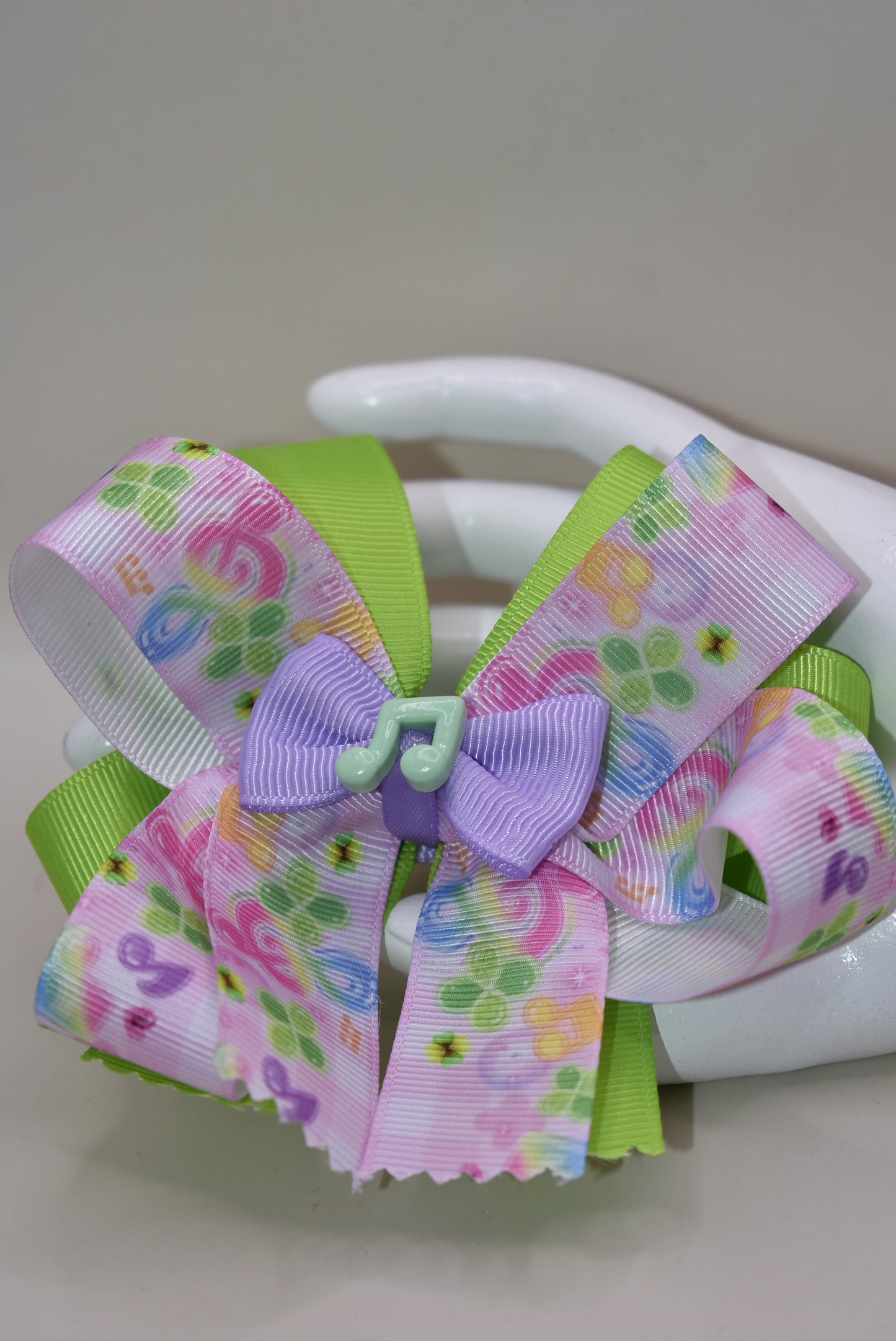 Perfect for your little music enthusiast! 🎵 This adorable bow features musical ribbon topped with a cute note charm, creating a harmonious accessory she'll love! 🎀 Securely attached to a wrapped alligator clip for comfortable all-day wear without slipping. 🎶 Let her show off her musical spirit with this playful addition to Nana's Collection! 💕