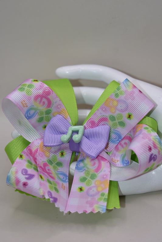 Perfect for your little music enthusiast! 🎵 This adorable bow features musical ribbon topped with a cute note charm, creating a harmonious accessory she'll love! 🎀 Securely attached to a wrapped alligator clip for comfortable all-day wear without slipping. 🎶 Let her show off her musical spirit with this playful addition to Nana's Collection! 💕