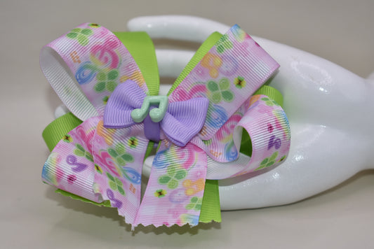 Perfect for your little music enthusiast! 🎵 This adorable bow features musical ribbon topped with a cute note charm, creating a harmonious accessory she'll love! 🎀 Securely attached to a wrapped alligator clip for comfortable all-day wear without slipping. 🎶 Let her show off her musical spirit with this playful addition to Nana's Collection! 💕
