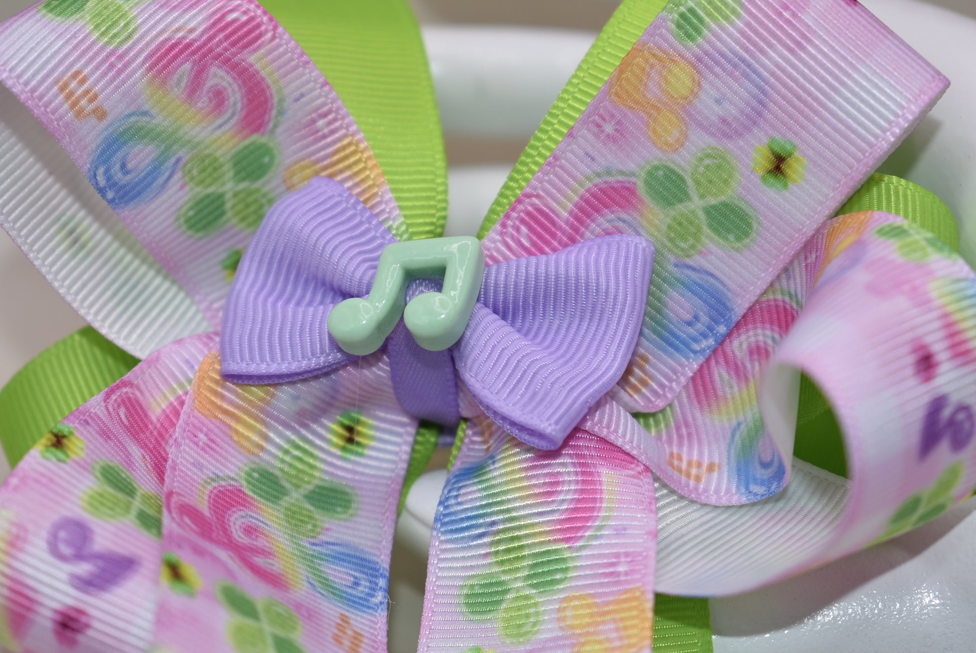 Perfect for your little music enthusiast! 🎵 This adorable bow features musical ribbon topped with a cute note charm, creating a harmonious accessory she'll love! 🎀 Securely attached to a wrapped alligator clip for comfortable all-day wear without slipping. 🎶 Let her show off her musical spirit with this playful addition to Nana's Collection! 💕