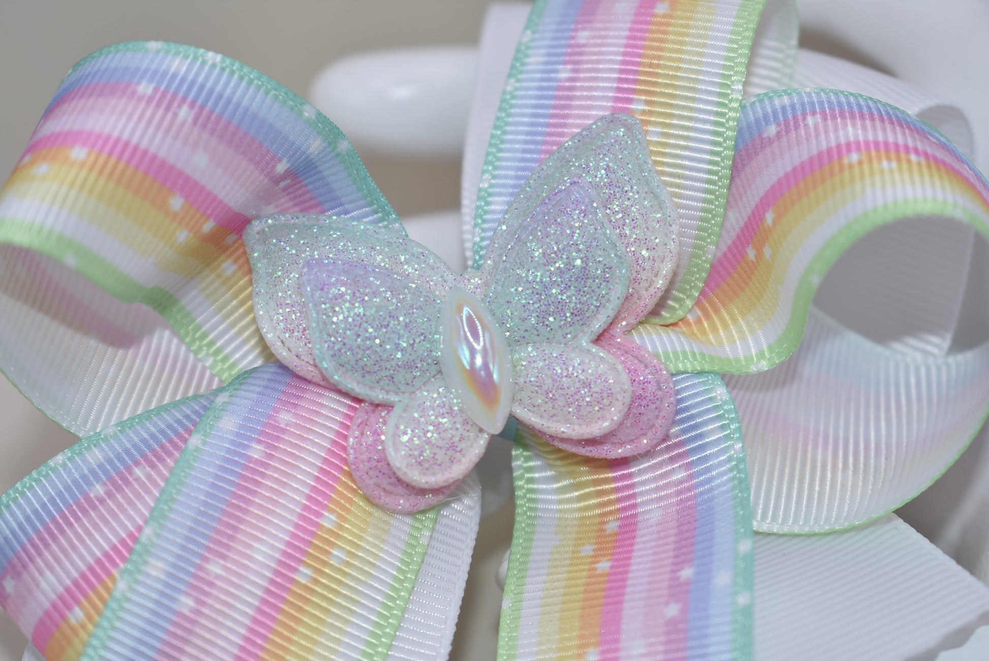 Elevate your little one's style with this enchanting pastel rainbow ribbon bow! 🌈✨ Topped with a sparkly butterfly that catches the light, this adorable hair accessory brings magical charm to any outfit. 🦋 The secure alligator clip ensures it stays put through all her adventures! Perfect for your color-loving princess who wants to stand out with playful flair. 💕 #NanasCollection