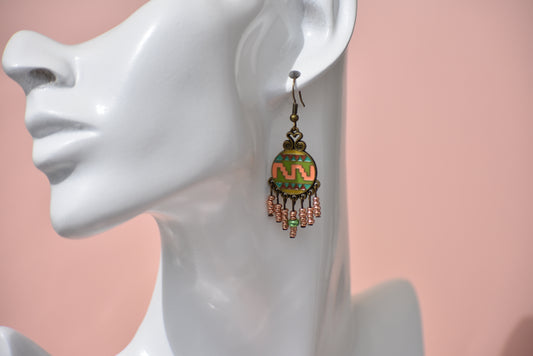 The Western Collection earrings will be the talk of the town! These unique bronze hook earrings are hypoallergenic and feature a stunning Aztec pattern of peach, rust, and green colors. Plus, they come with six hanging strands of copper beading that hang beautifully on the ear. You won't want to miss these!