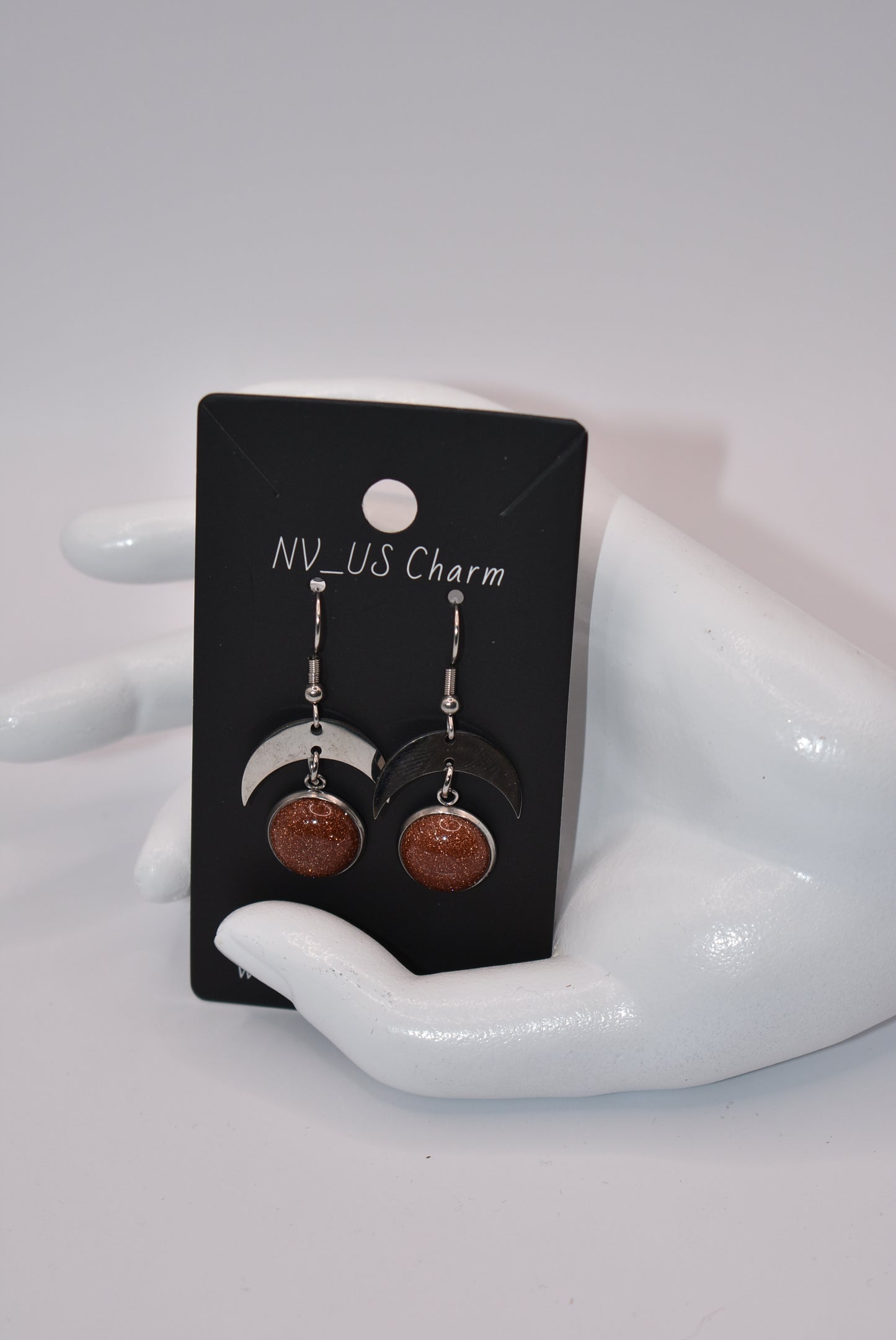 Introducing the Brown Collection - stylish stainless-steel earrings with a cabochon copper sparkly stone. These earrings feature a comfortable half-moon design and pair perfectly with any outfit (you'll love them!). Upgrade your accessory game and add a touch of sparkle with these unique earrings.