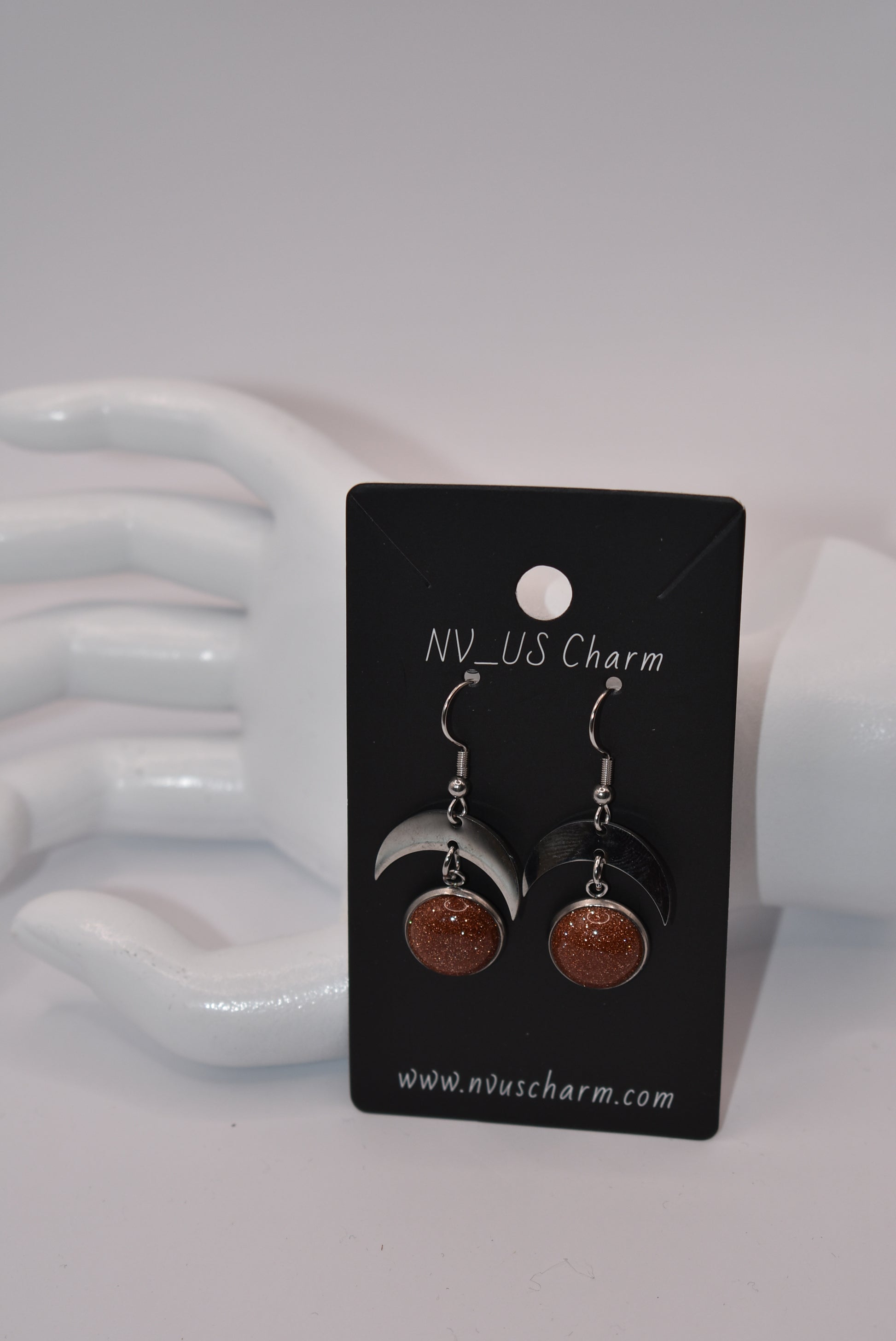 Introducing the Brown Collection - stylish stainless-steel earrings with a cabochon copper sparkly stone. These earrings feature a comfortable half-moon design and pair perfectly with any outfit (you'll love them!). Upgrade your accessory game and add a touch of sparkle with these unique earrings.