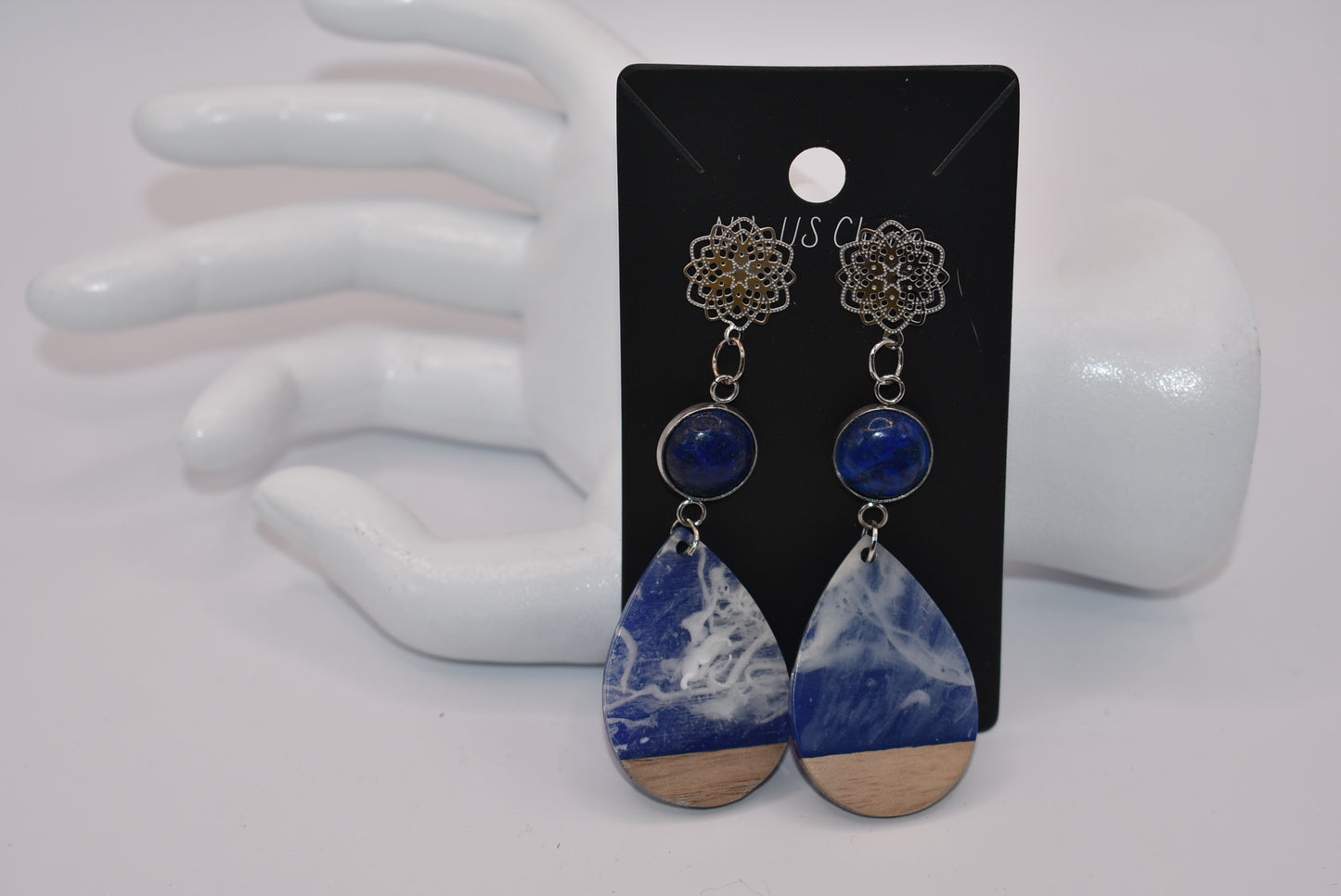 Unleash your unique style with the Blue Collection! This one-of-a-kind piece features a blue cabochon stone on a long silver filigree post, with a resin and wood teardrop that hangs around 2 1/2 inches for a chic look. Hypoallergenic posts make it super comfortable for sensitive ears.