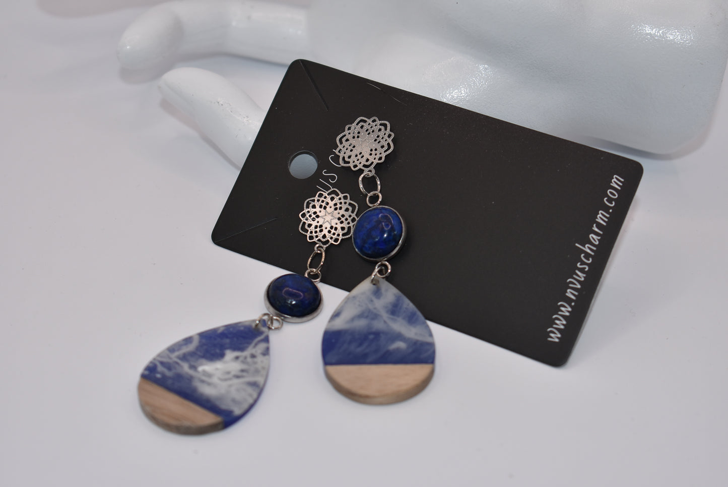 Unleash your unique style with the Blue Collection! This one-of-a-kind piece features a blue cabochon stone on a long silver filigree post, with a resin and wood teardrop that hangs around 2 1/2 inches for a chic look. Hypoallergenic posts make it super comfortable for sensitive ears.