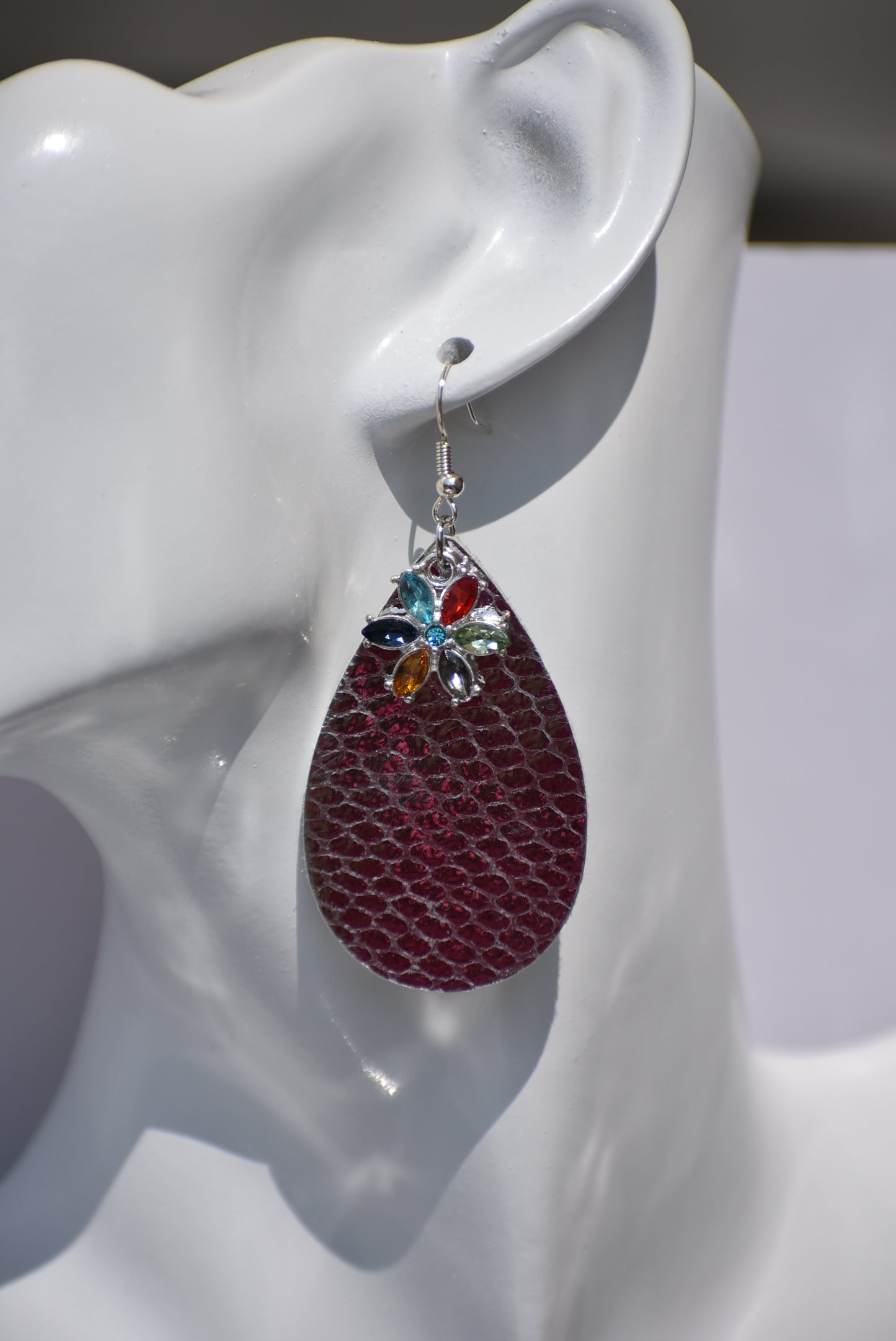 These pretty silver metallic teardrop earrings have a colored crystal flower hanging down and are on silver hooks.  Super comfortable.  Goes with everything.  