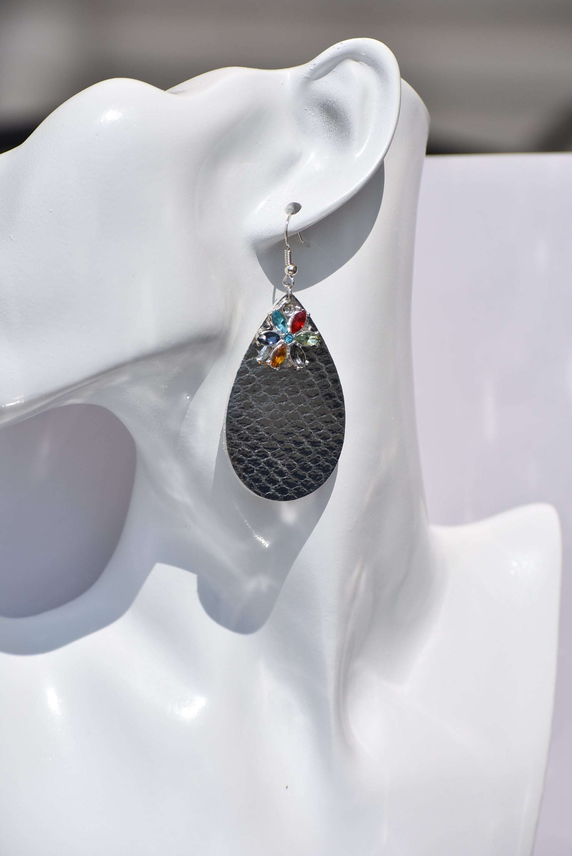 These pretty silver metallic teardrop earrings have a colored crystal flower hanging down and are on silver hooks.  Super comfortable.  Goes with everything.  