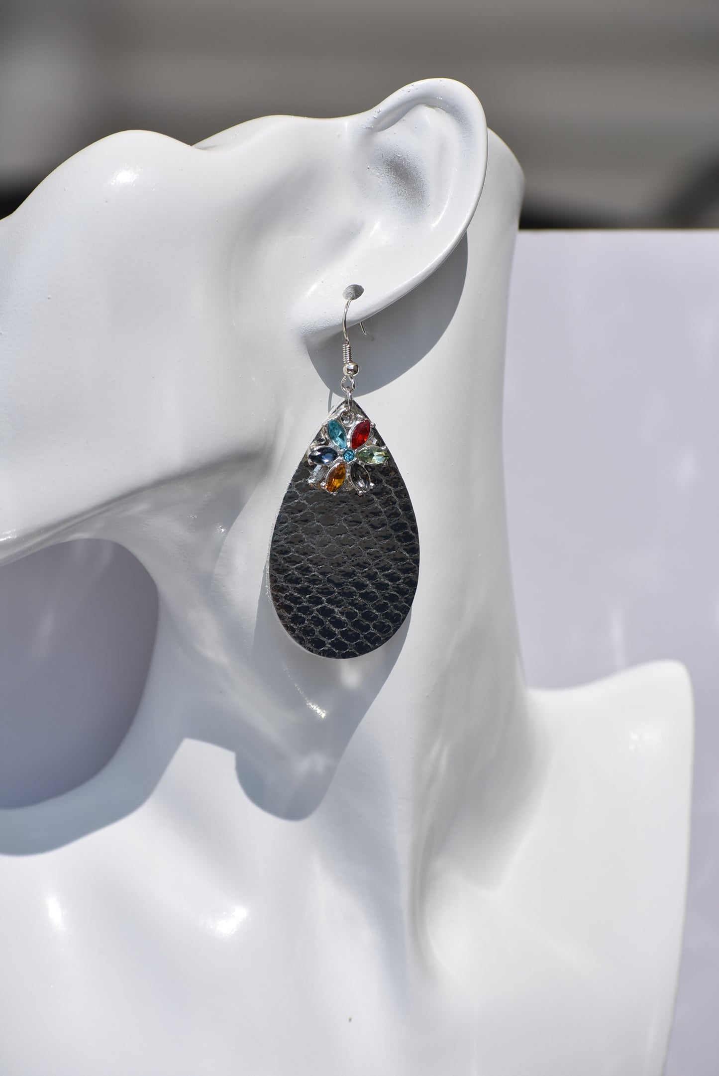 These pretty silver metallic teardrop earrings have a colored crystal flower hanging down and are on silver hooks.  Super comfortable.  Goes with everything.  