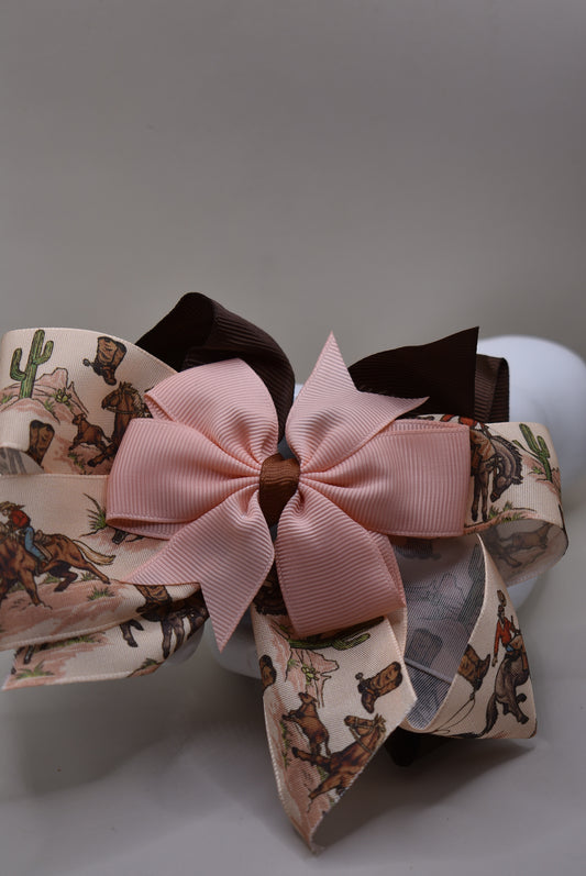 Add a splash of charm with this one-of-a-kind cowgirl bow! 🤠 A large brown grosgrain ribbon showcases a delicate cowgirl motif, topped with a sweet peach bow 🎀. Securely fastened with an alligator clip, it stays put while you shine! Perfect for little cowgirls ready to twirl and play. 🌟🐴