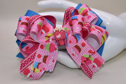 Add a splash of fun with this adorable cupcake ribbon bow, wrapped in bright, multi-colored grosgrain ribbons! 🧁✨ The cutest little charm tops it off, making it perfect for any playful outfit. Finished with a wrapped alligator clip on the back for easy wear and secure hold. 🎀💖 Perfect for adding a sweet touch to your day!
