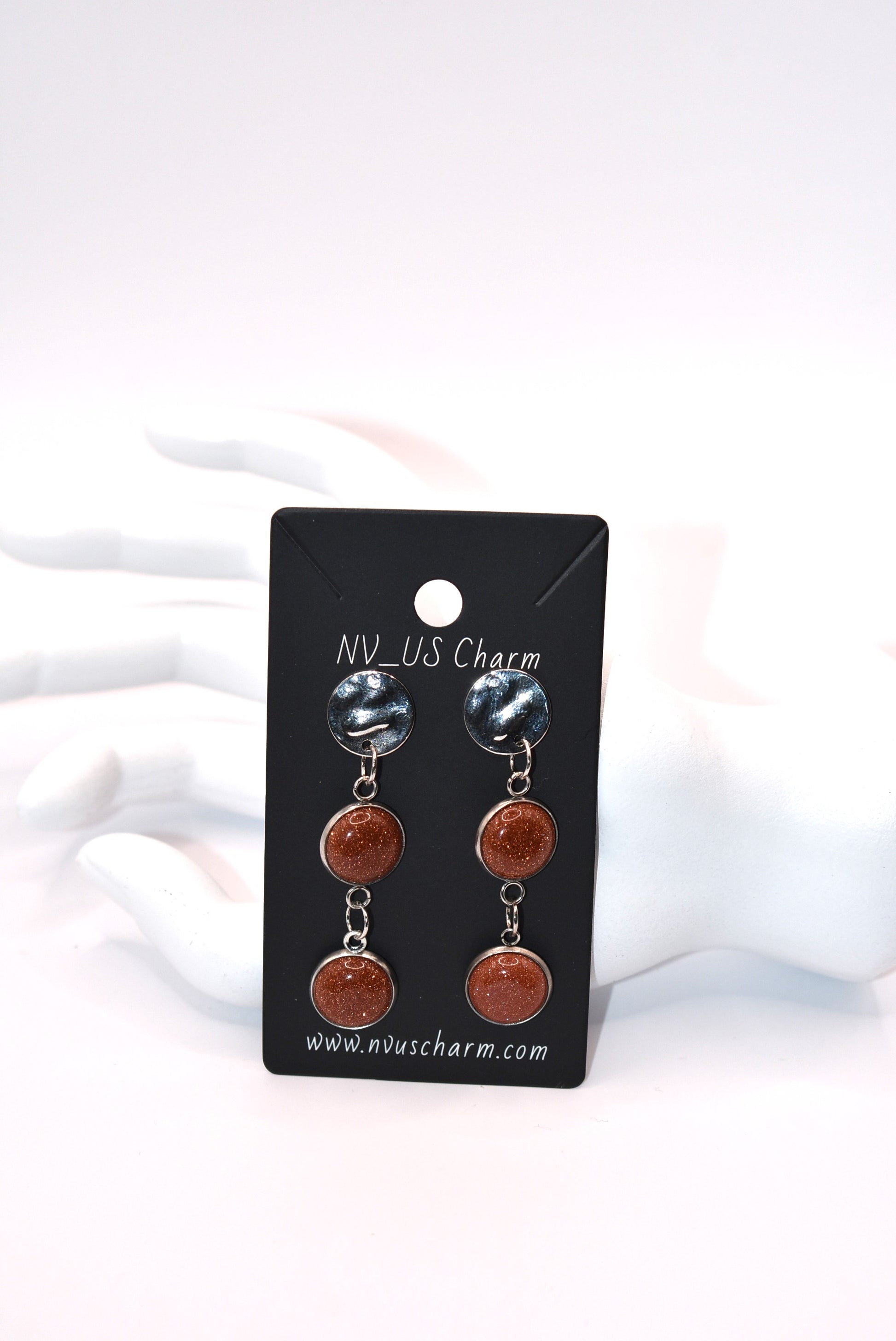 Add a touch of whimsy to any outfit with our Brown Collection earrings! These super comfortable and stylish earrings feature beautiful copper sparkling cabochon stones and hypoallergenic silver posts for sensitive ears. With a versatile neutral color, they'll easily complement any look. Earrings hang 2 inches from the ear for a perfect statement.