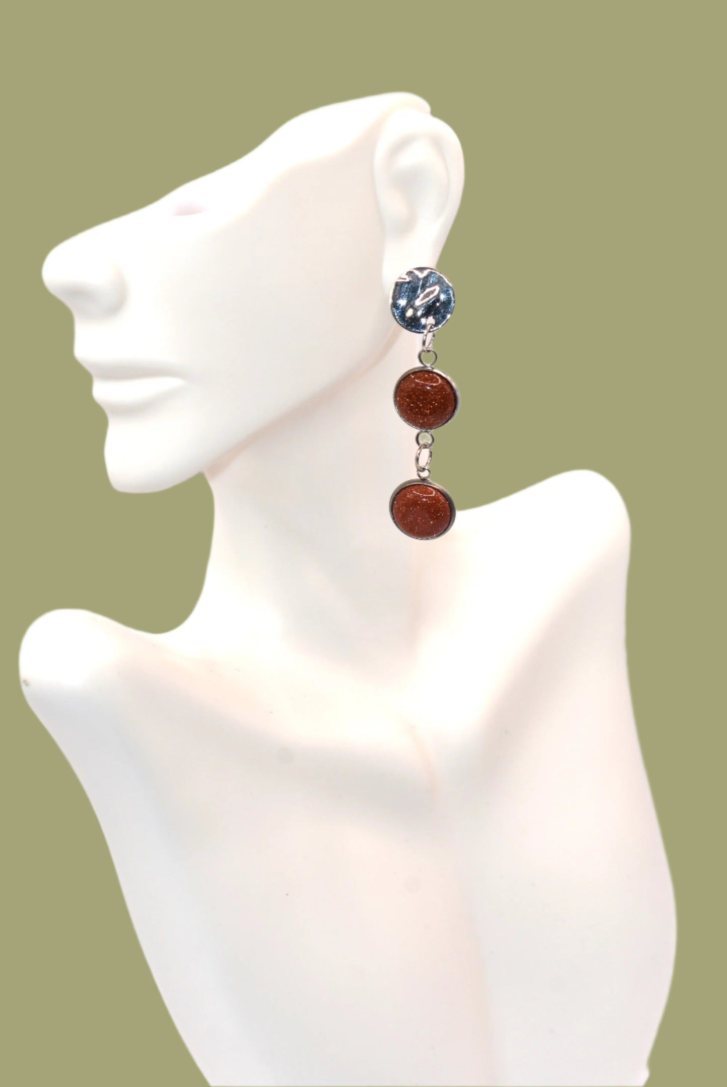 Add a touch of whimsy to any outfit with our Brown Collection earrings! These super comfortable and stylish earrings feature beautiful copper sparkling cabochon stones and hypoallergenic silver posts for sensitive ears. With a versatile neutral color, they'll easily complement any look. Earrings hang 2 inches from the ear for a perfect statement.