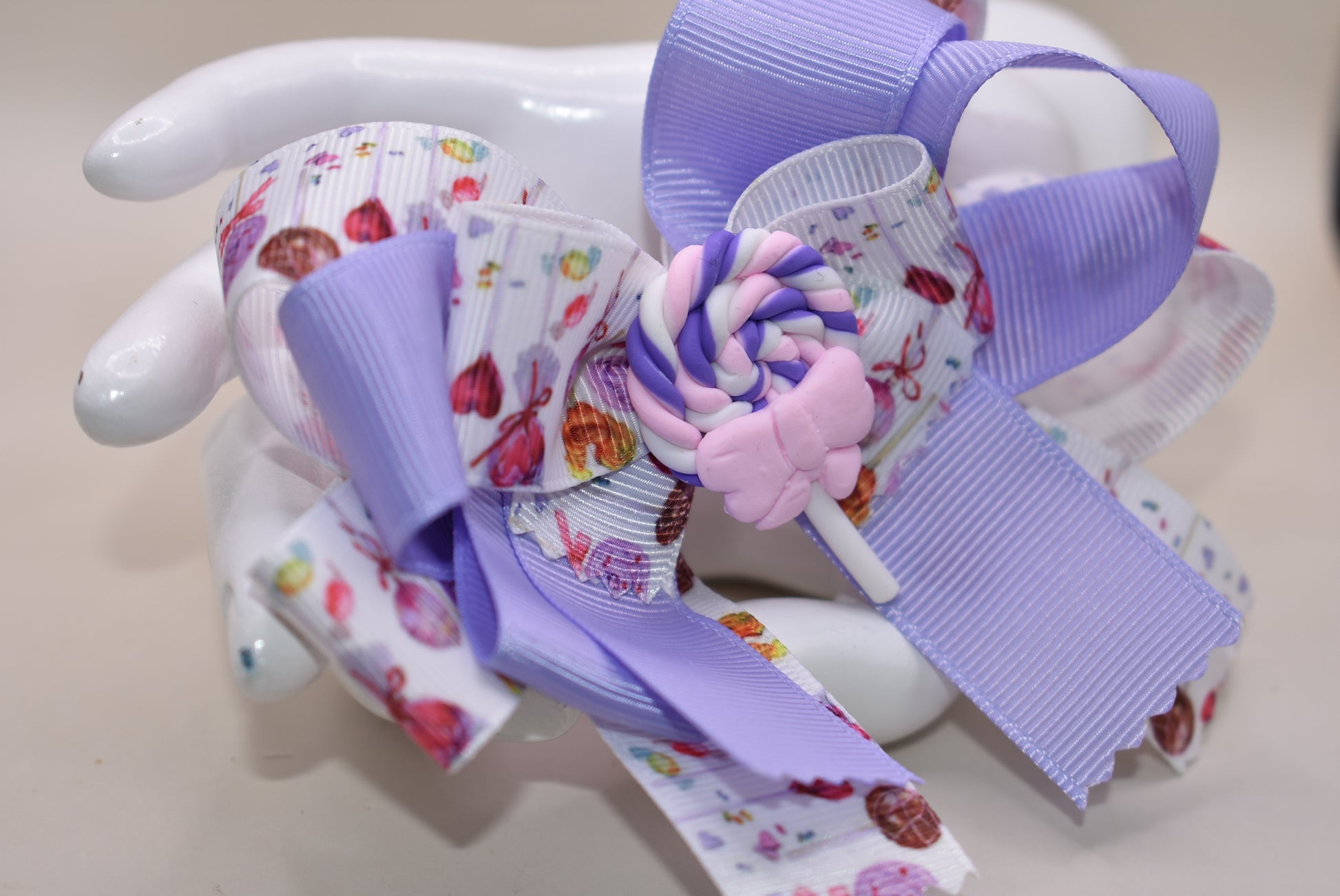 Add a splash of sweetness with Nana's Collection 124! 🍭 This adorable lollipop bow blends soft lavender and pink hues, making it impossible not to love. Perfectly playful and charming, it’s secured with a wrapped alligator clip for easy wear. Get ready to brighten any outfit with this cutie! 💜🎀