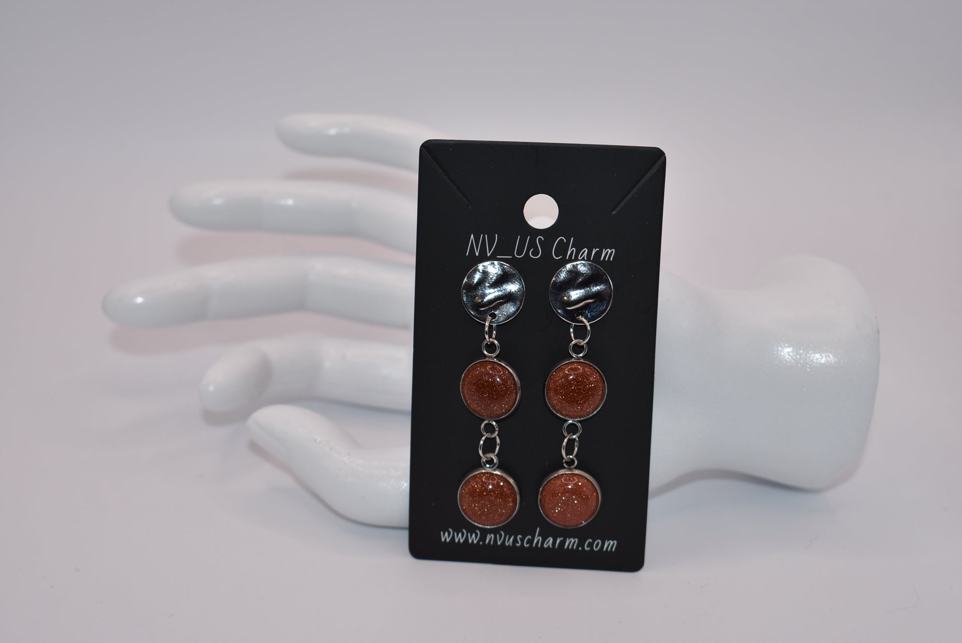 Add a touch of whimsy to any outfit with our Brown Collection earrings! These super comfortable and stylish earrings feature beautiful copper sparkling cabochon stones and hypoallergenic silver posts for sensitive ears. With a versatile neutral color, they'll easily complement any look. Earrings hang 2 inches from the ear for a perfect statement.