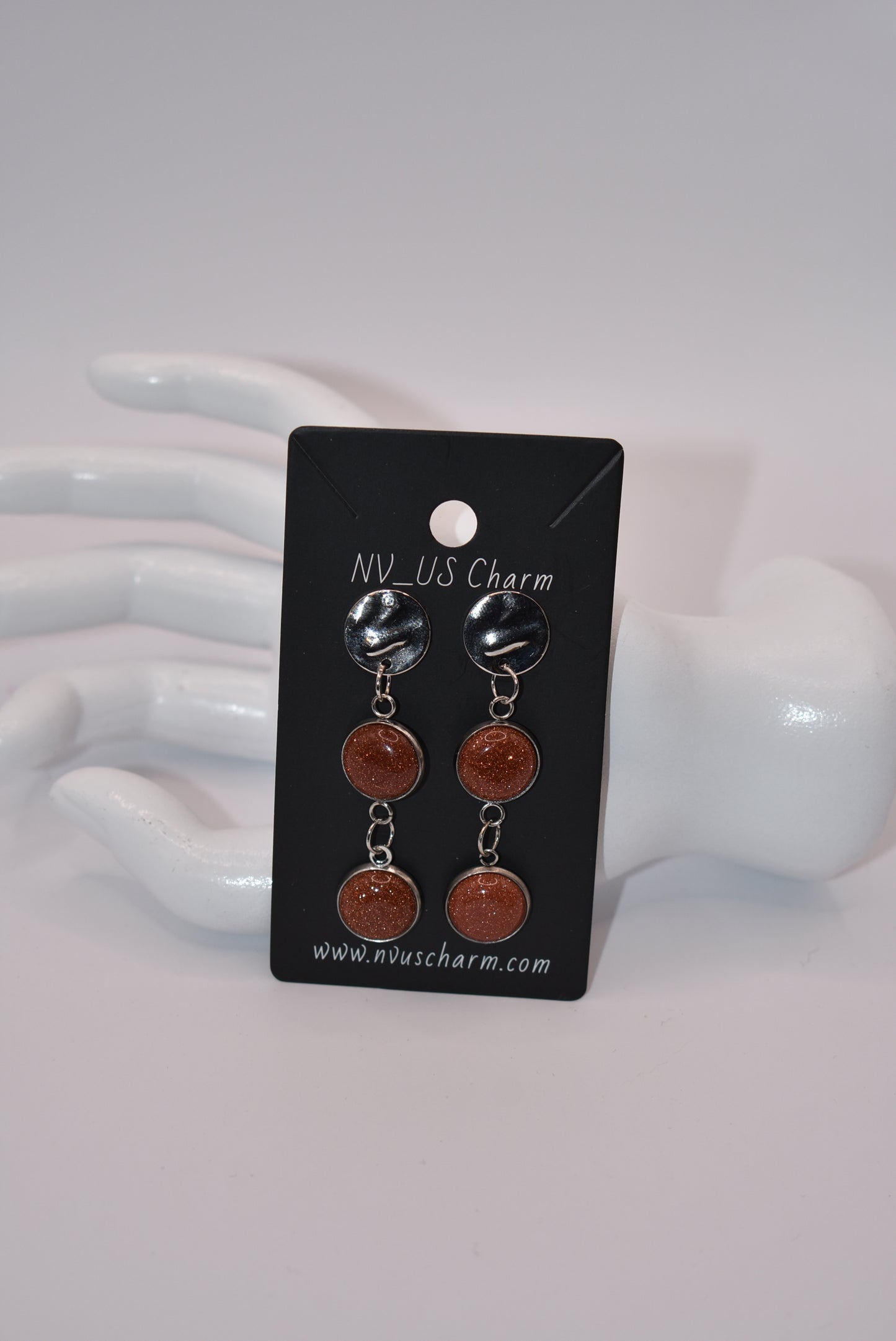 Add a touch of whimsy to any outfit with our Brown Collection earrings! These super comfortable and stylish earrings feature beautiful copper sparkling cabochon stones and hypoallergenic silver posts for sensitive ears. With a versatile neutral color, they'll easily complement any look. Earrings hang 2 inches from the ear for a perfect statement.