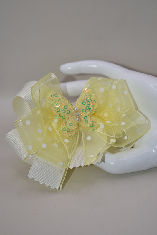 Add a splash of sunshine with this adorable bow from Nana's Collection! 🌼 Soft baby yellow grosgrain and delicate organza ribbons tie together a playful polka dot bow, topped with a sparkly butterfly 🦋. Secured with a wrapped alligator clip, it stays put for all-day fun. Perfect for brightening any outfit with a touch of charm and sparkle! ✨