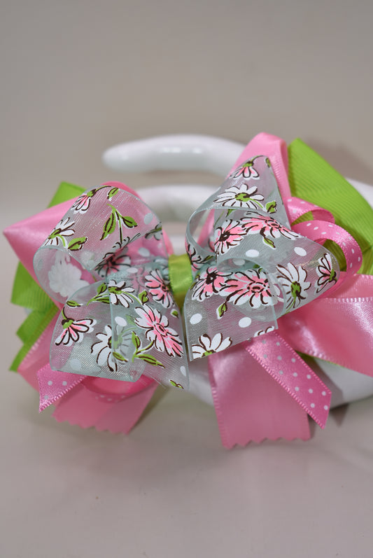 Add a splash of charm with Nana's Collection 106! 🌸 Delightful layers of silk, grosgrain, and organza ribbons in soft pinks and greens create a sweet, playful look. The delicate flower design on the organza ribbon adds an extra touch of whimsy 🌷. Finished with a wrapped alligator clip, it stays put all day for endless fun! 🎀✨