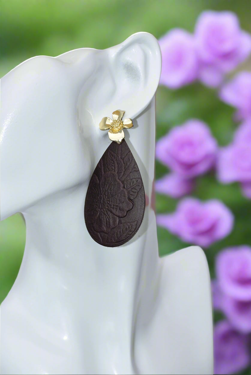 Experience the beauty of the Brown Collection. Crafted with dark brown flower-pressed faux leather in a unique teardrop shape. The elegant gold flower post earrings add a touch of glamour. Hypoallergenic and infused with Hawaiian flair, these earrings are perfect for any occasion.