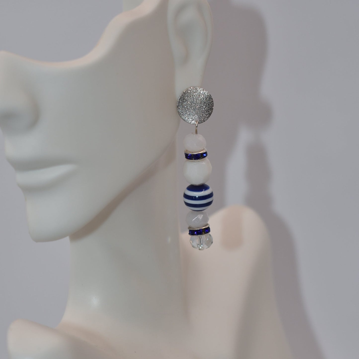 Step aboard and add a touch of sparkle to your nautical wardrobe with our one-of-a-kind Nautical Collection earrings. The silver, hypoallergenic, sparkly posts and mix of white and blue beads and crystals add a playful yet stylish touch to any outfit. "Sea" for yourself!