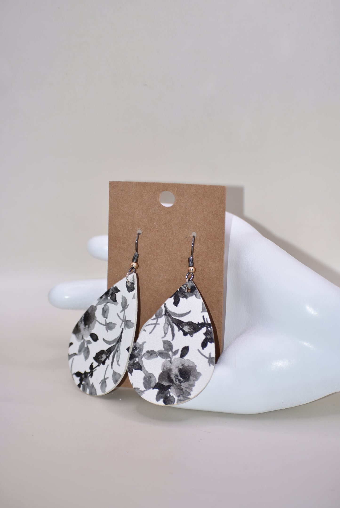 Add a touch of playfulness to any outfit with our Key West Collection earrings! These unique faux leather teardrop earrings feature a pretty black and white flower design and a quirky black hook with a gold ball. Comfortable yet stylish, they're perfect for dressing up or down. 😉