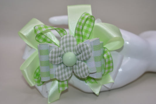 Add a splash of fun with this playful green and white checkered ribbon bow from Nana's Collection. Its charming pattern brings a lively touch to any outfit, while the covered alligator clip ensures it stays put comfortably all day. Perfect for adding a cute, cheerful accent wherever you go!