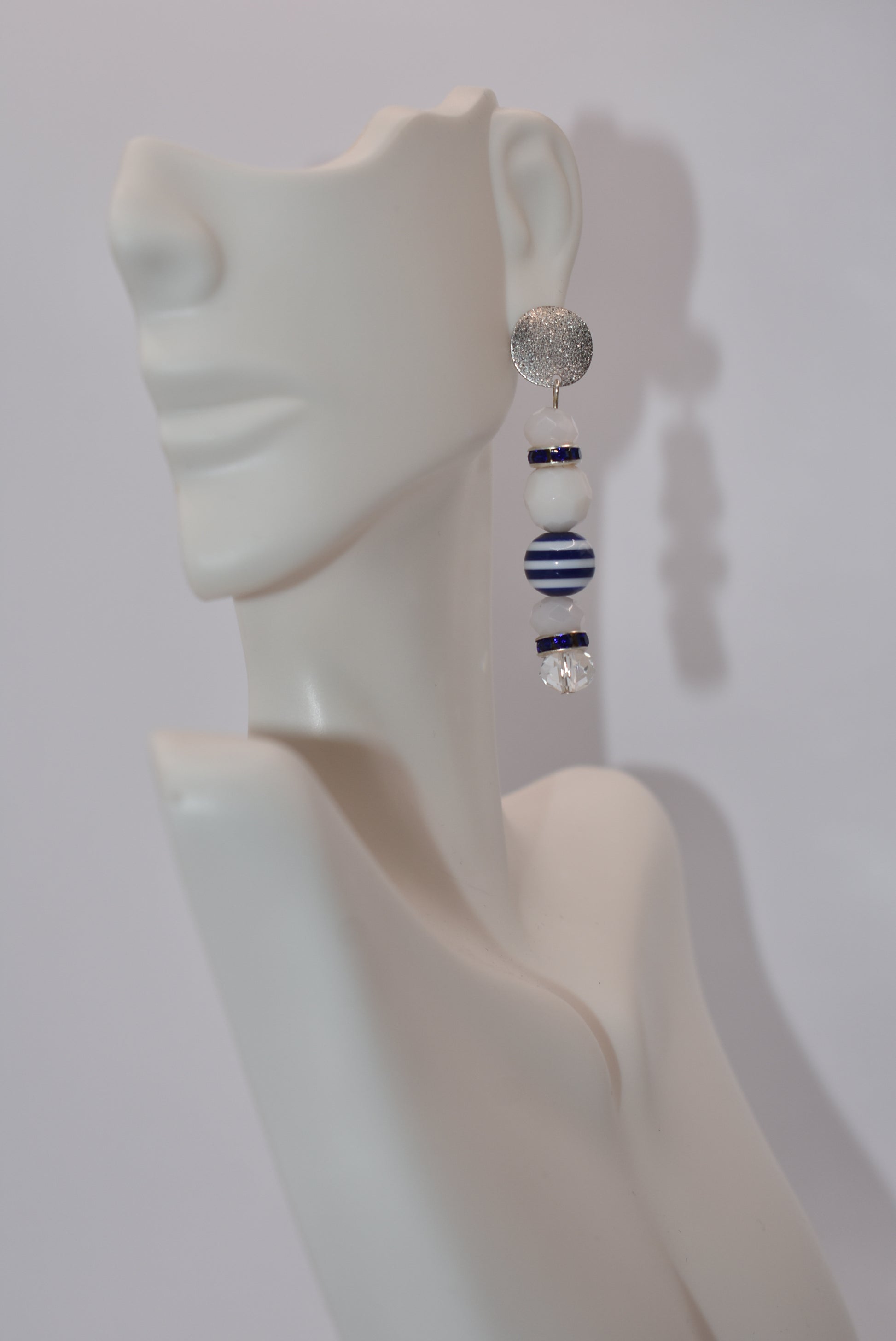 Step aboard and add a touch of sparkle to your nautical wardrobe with our one-of-a-kind Nautical Collection earrings. The silver, hypoallergenic, sparkly posts and mix of white and blue beads and crystals add a playful yet stylish touch to any outfit. "Sea" for yourself!