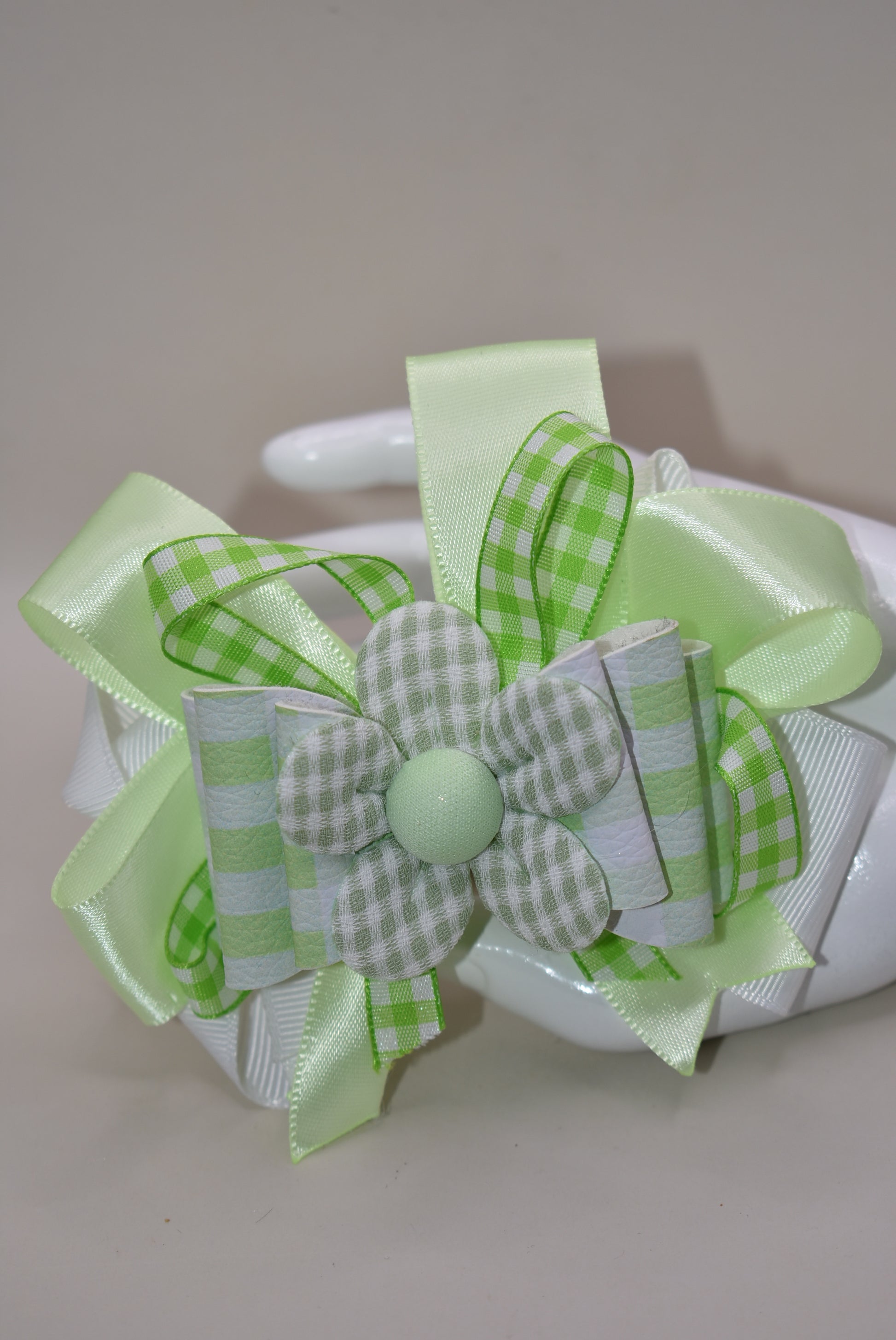 Add a splash of fun with this playful green and white checkered ribbon bow from Nana's Collection. Its charming pattern brings a lively touch to any outfit, while the covered alligator clip ensures it stays put comfortably all day. Perfect for adding a cute, cheerful accent wherever you go!