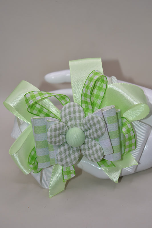 Add a splash of fun with this playful green and white checkered ribbon bow from Nana's Collection. Its charming pattern brings a lively touch to any outfit, while the covered alligator clip ensures it stays put comfortably all day. Perfect for adding a cute, cheerful accent wherever you go!