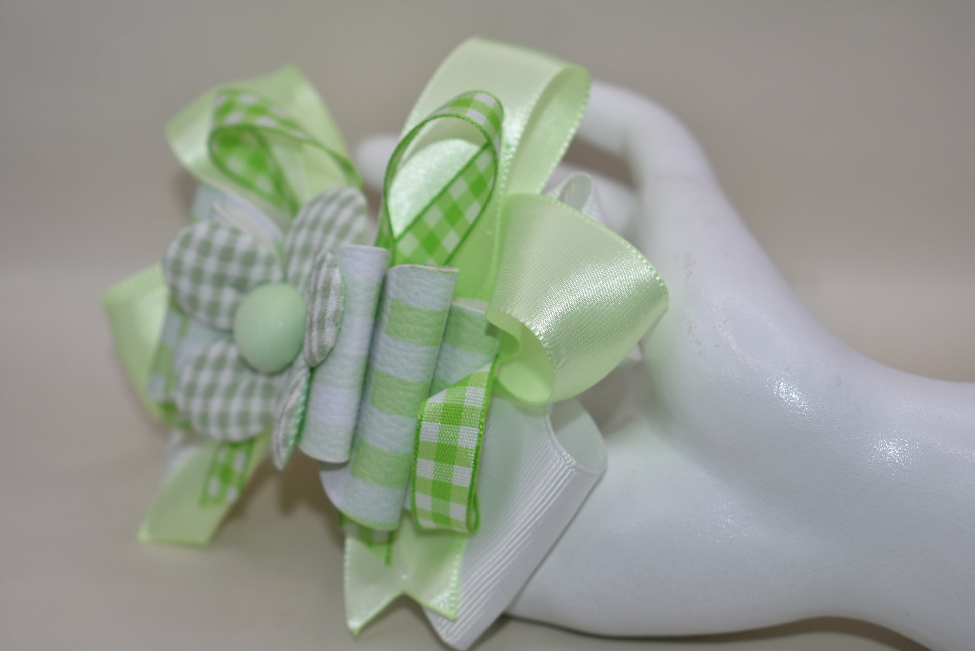 Add a splash of fun with this playful green and white checkered ribbon bow from Nana's Collection. Its charming pattern brings a lively touch to any outfit, while the covered alligator clip ensures it stays put comfortably all day. Perfect for adding a cute, cheerful accent wherever you go!